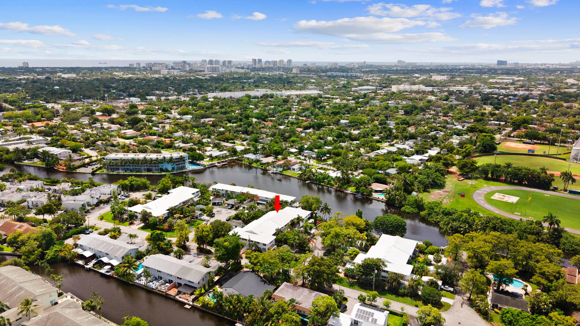 7 Middlesex Drive, Wilton Manors, FL 33305 Expansive riverside property featuring multiple white structures set across lush, mature landscaping