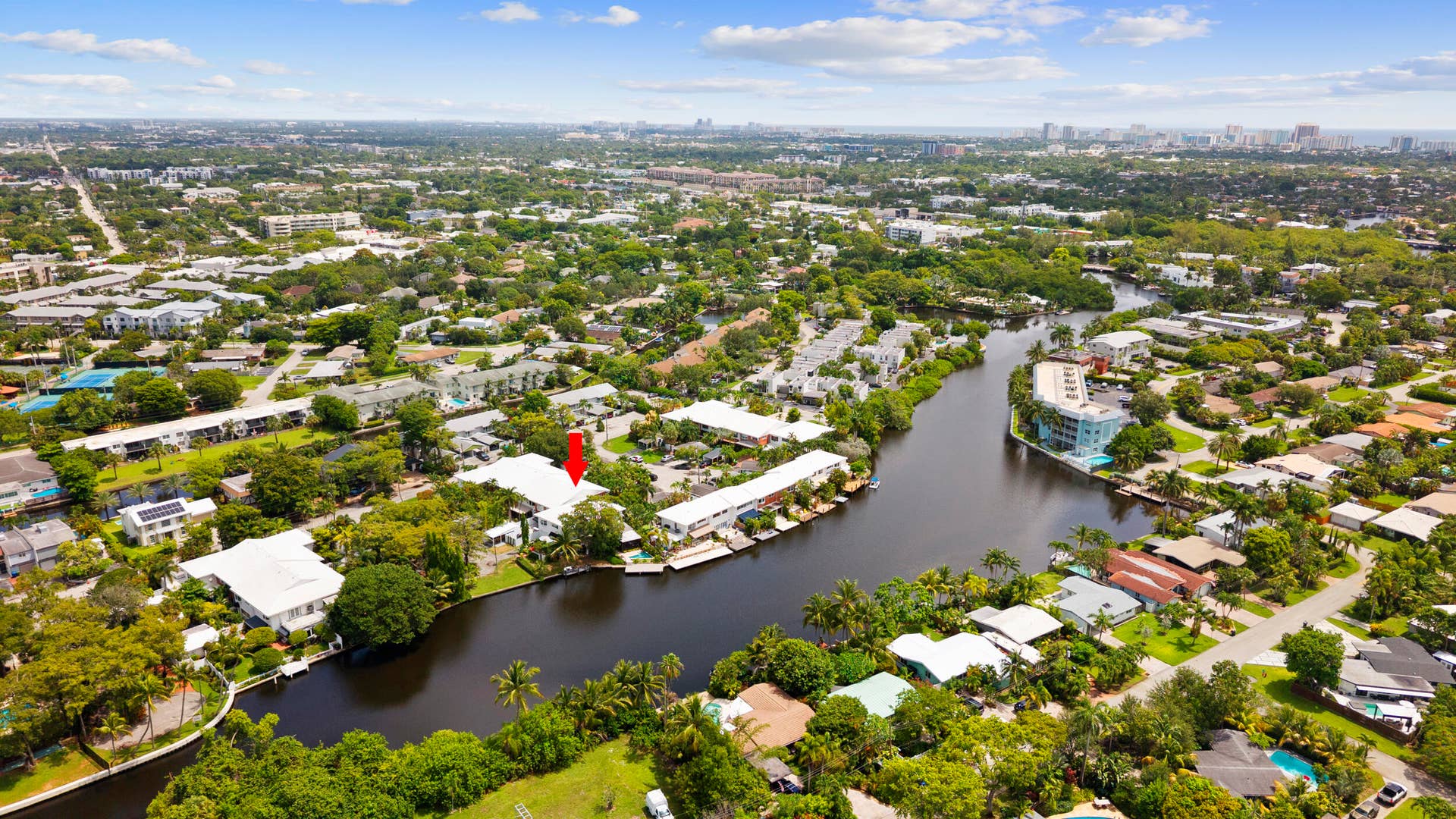 7 Middlesex Drive, Wilton Manors, FL 33305 Aerial perspective showcasing a waterfront property nestled within a lush, tree-lined community