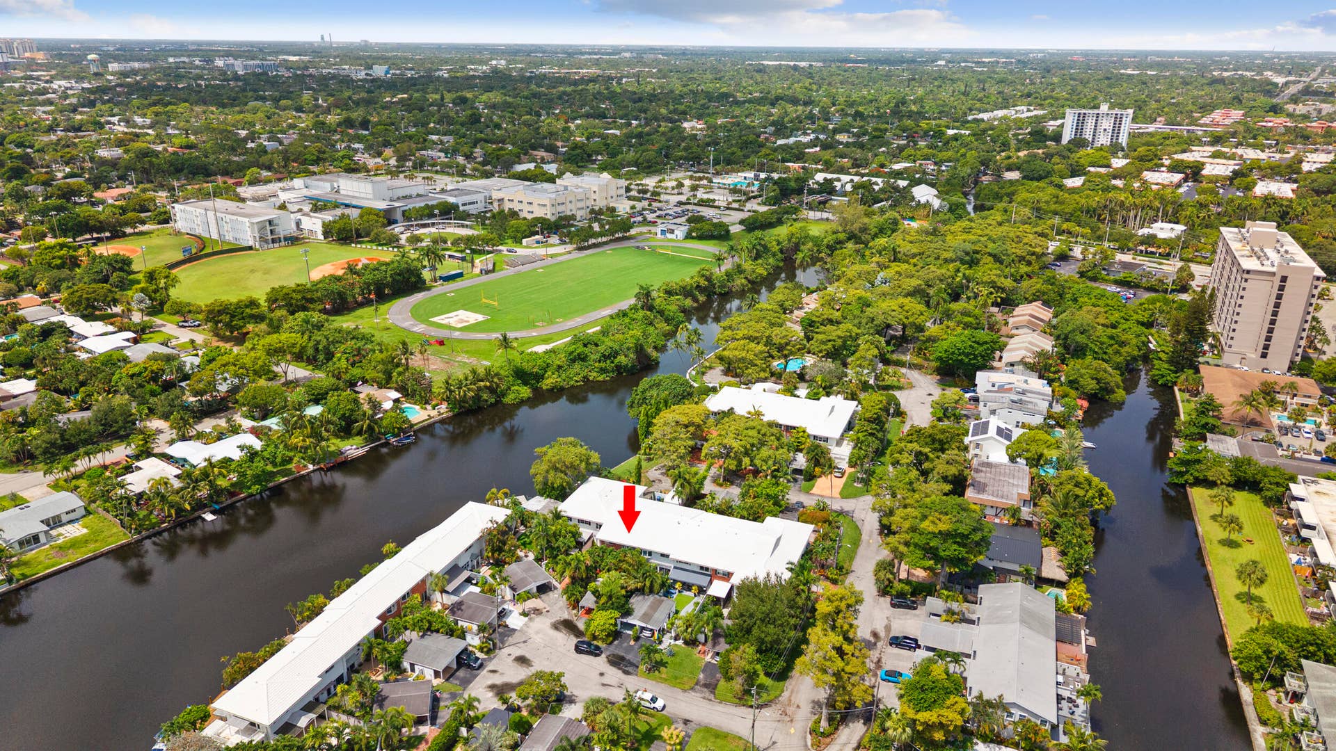 7 Middlesex Drive, Wilton Manors, FL 33305 Waterfront property featuring expansive grounds with mature landscaping, private riverfront access, and manicured lawn areas