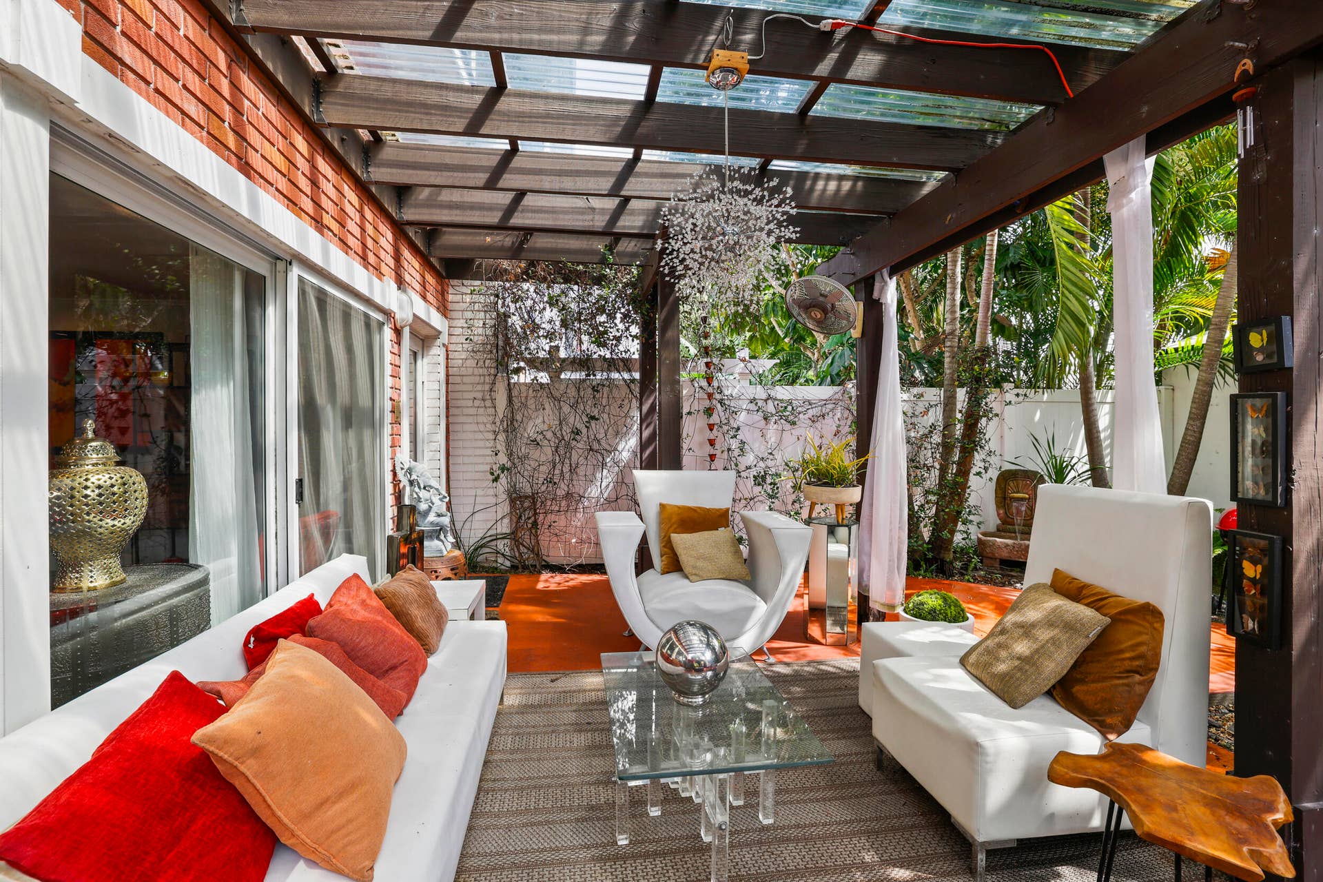 7 Middlesex Drive, Wilton Manors, FL 33305 Covered loggia with polished concrete flooring, featuring a white upholstered seating arrangement with coordinating throw pillows in warm tones