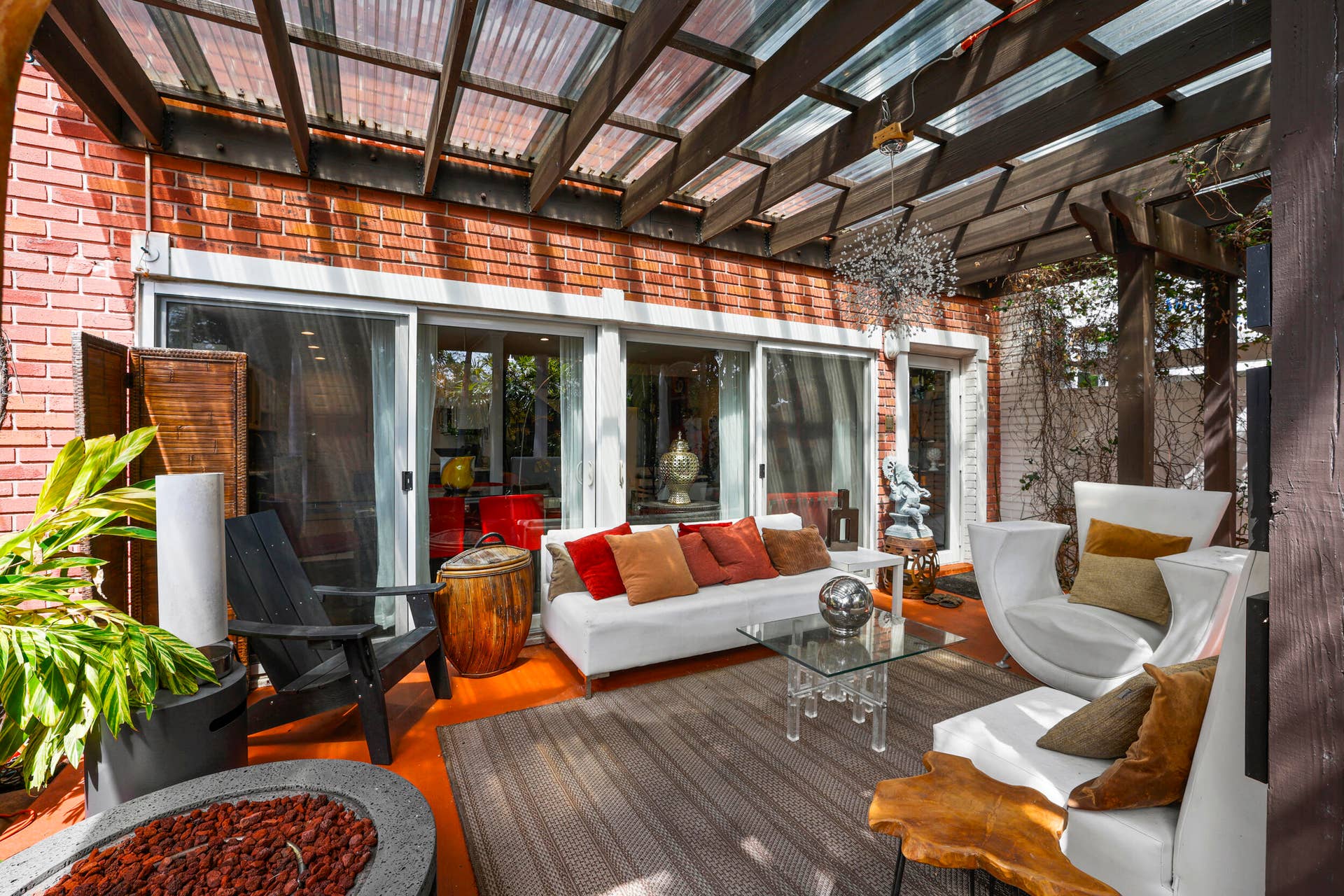 7 Middlesex Drive, Wilton Manors, FL 33305 Covered patio with polished wood-finish flooring, white-framed glass sliding doors, and integrated pergola overhead