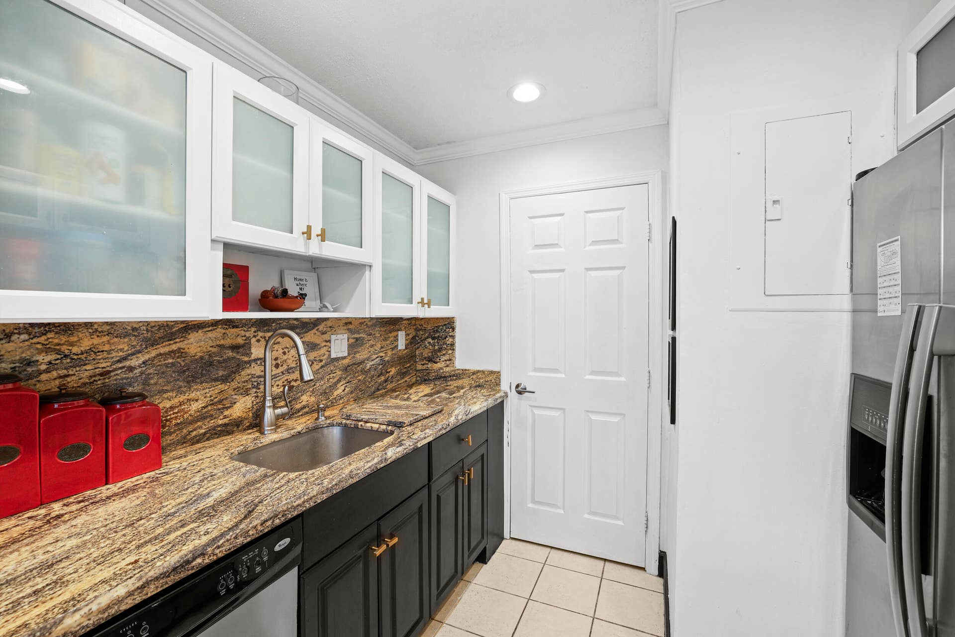 7 Middlesex Drive, Wilton Manors, FL 33305 Galley kitchen featuring granite countertops, stainless steel appliances, and a bronze faucet