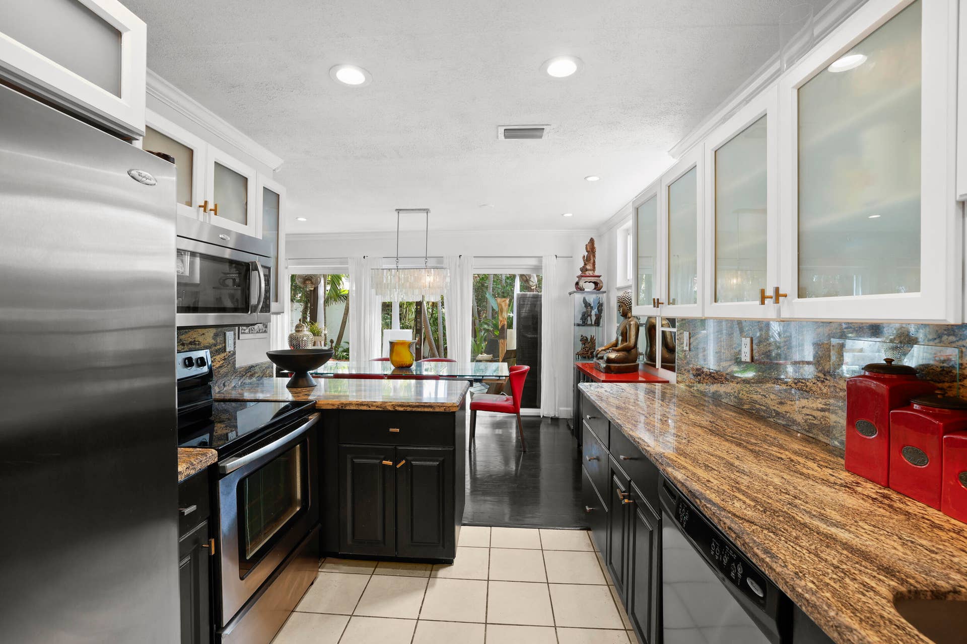 7 Middlesex Drive, Wilton Manors, FL 33305 Kitchen featuring stainless steel appliances, granite countertops, white upper cabinetry with glass inserts, dark lower cabinetry, and recessed lighting