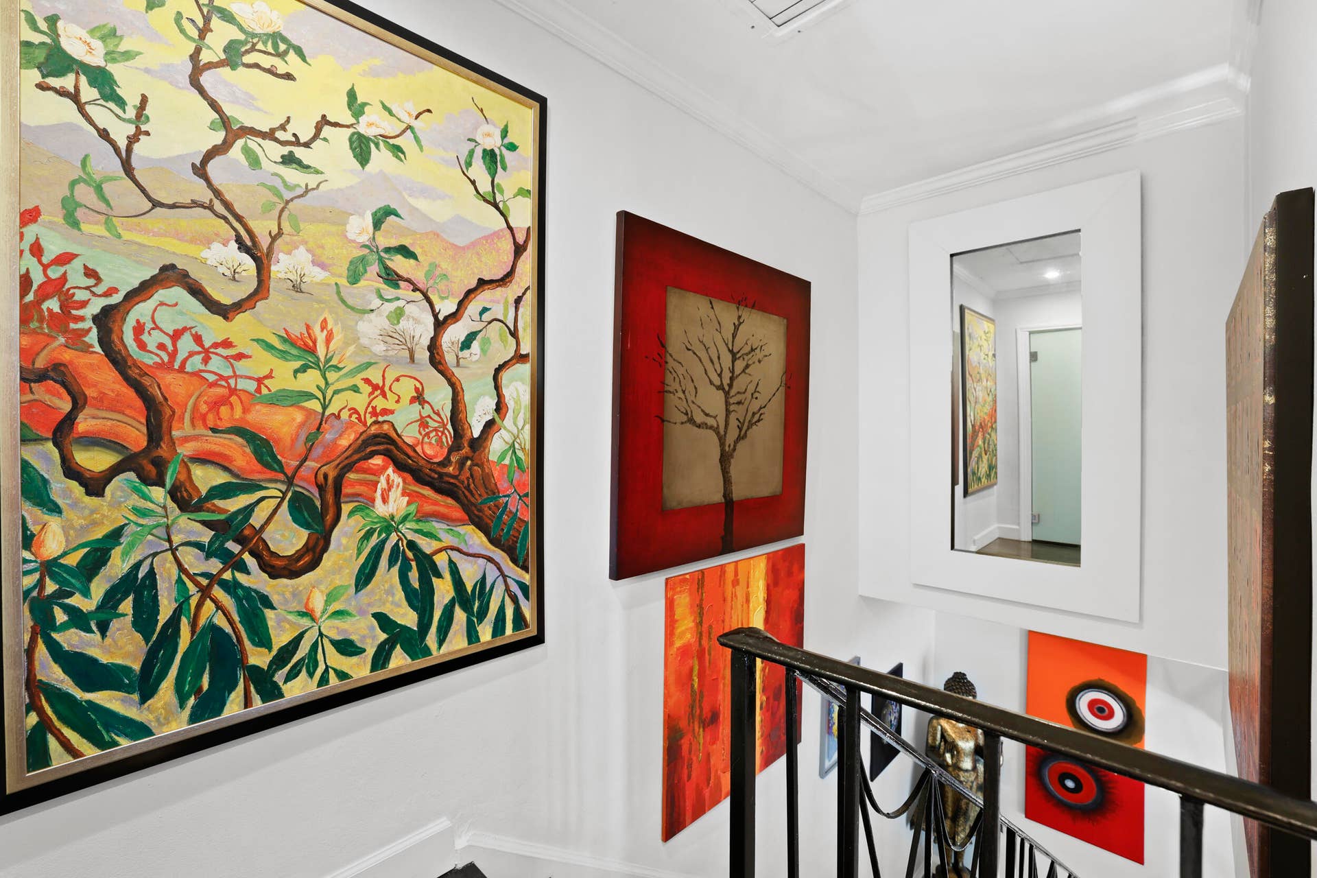 7 Middlesex Drive, Wilton Manors, FL 33305 Staircase landing featuring a framed wall mirror, crown molding, and wrought iron railings