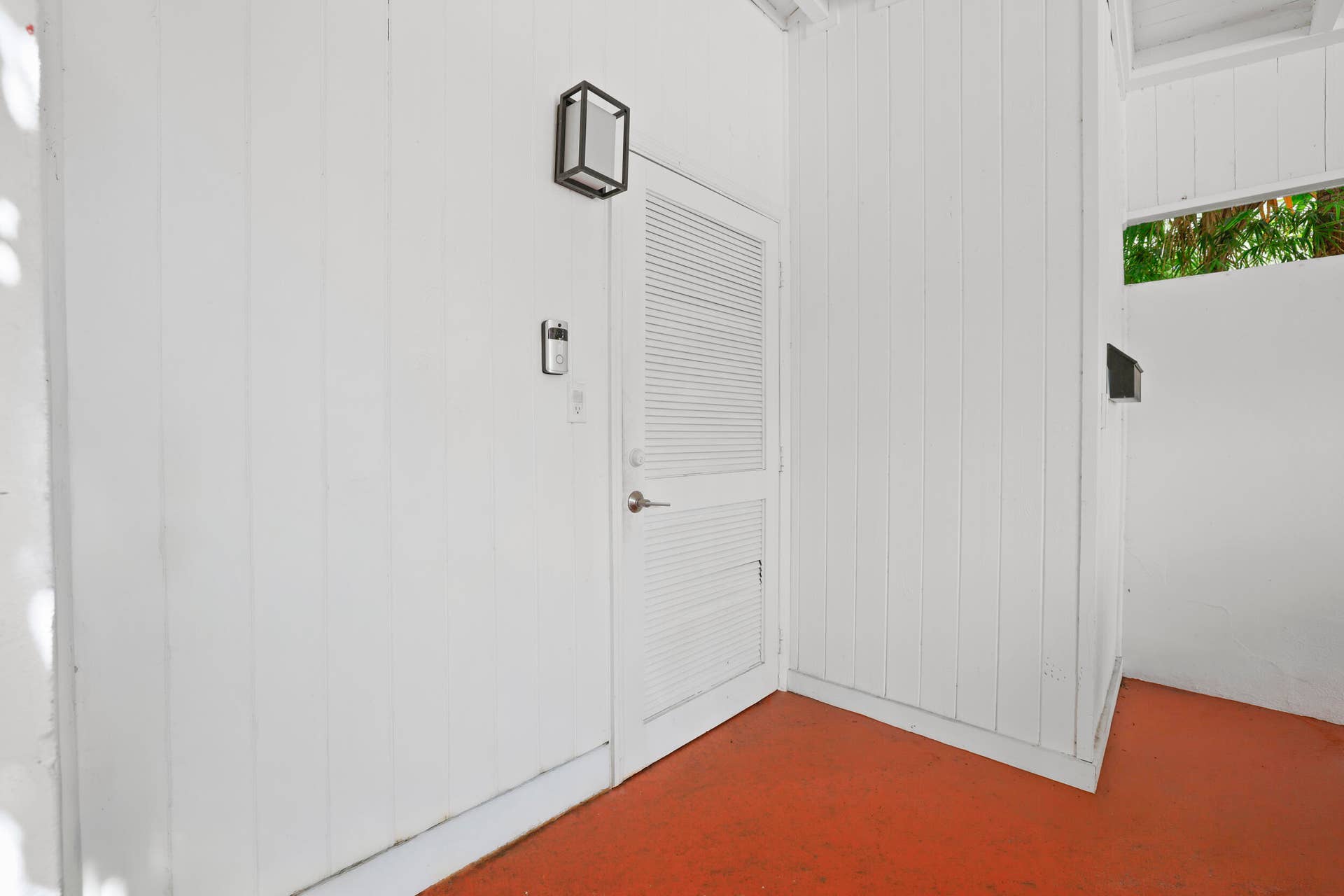 7 Middlesex Drive, Wilton Manors, FL 33305 Louvered door with a contemporary black wall-mounted lantern and a digital keypad entry system