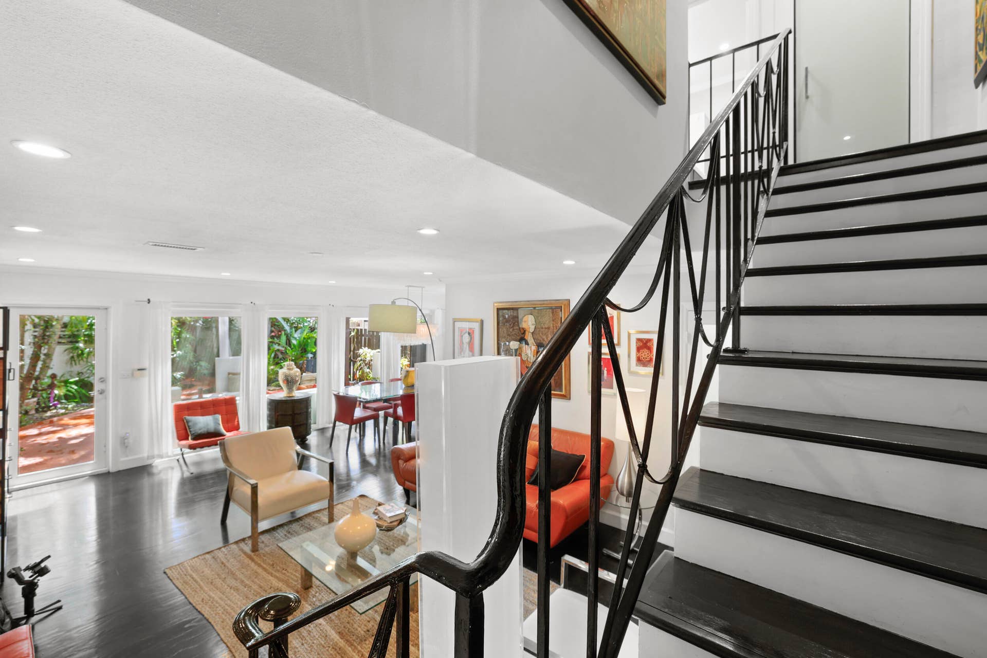7 Middlesex Drive, Wilton Manors, FL 33305 Modern staircase featuring black metal railings and dark wood-finish treads, anchoring an open-concept living space