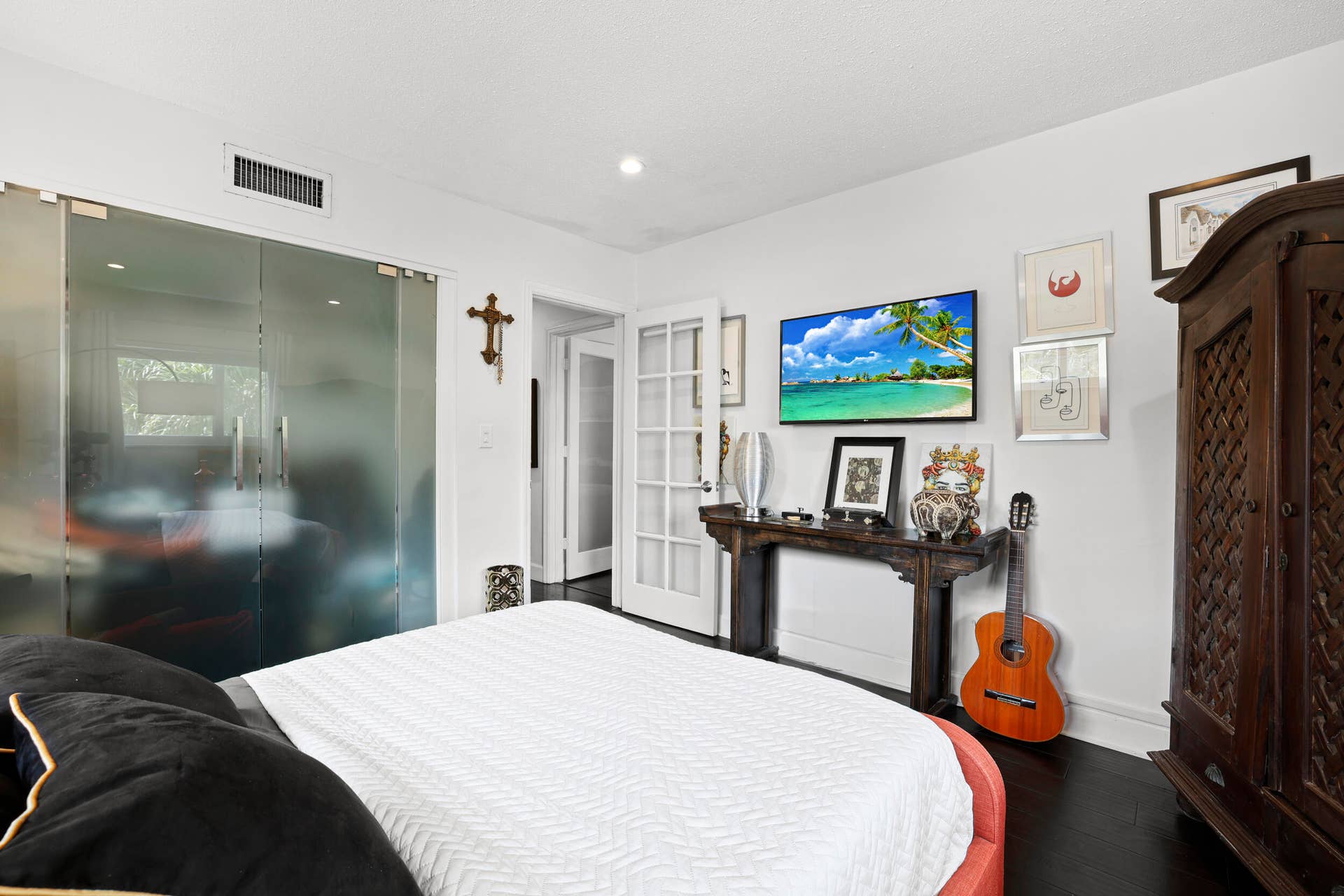 7 Middlesex Drive, Wilton Manors, FL 33305 Spacious primary bedroom featuring a contemporary ensuite with frameless glass shower enclosure, sleek floating vanity, and direct access to a walk-in closet