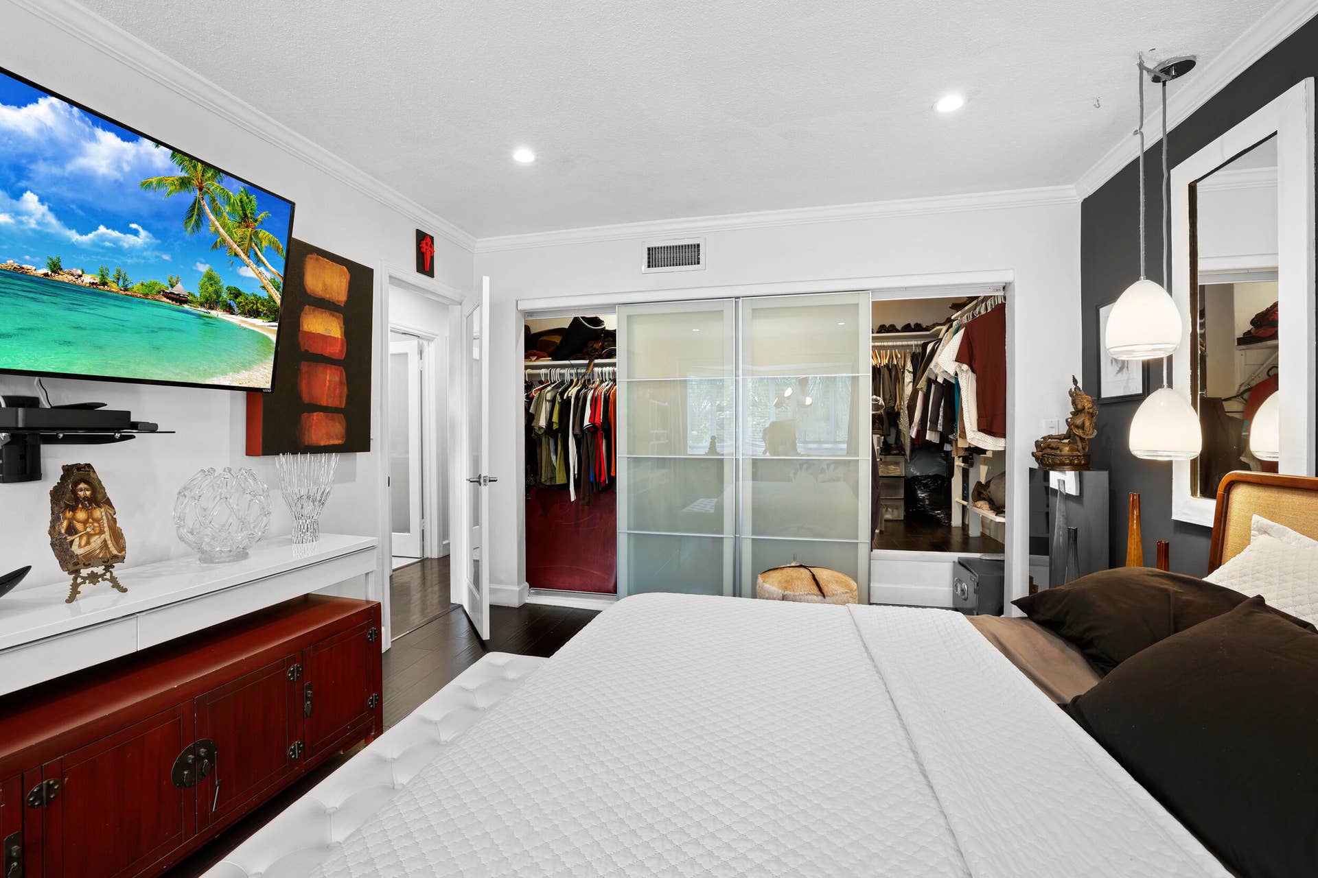 7 Middlesex Drive, Wilton Manors, FL 33305 Bedroom featuring dark wood-finish flooring, recessed lighting, crown molding, and a built-in closet with sliding frosted glass doors