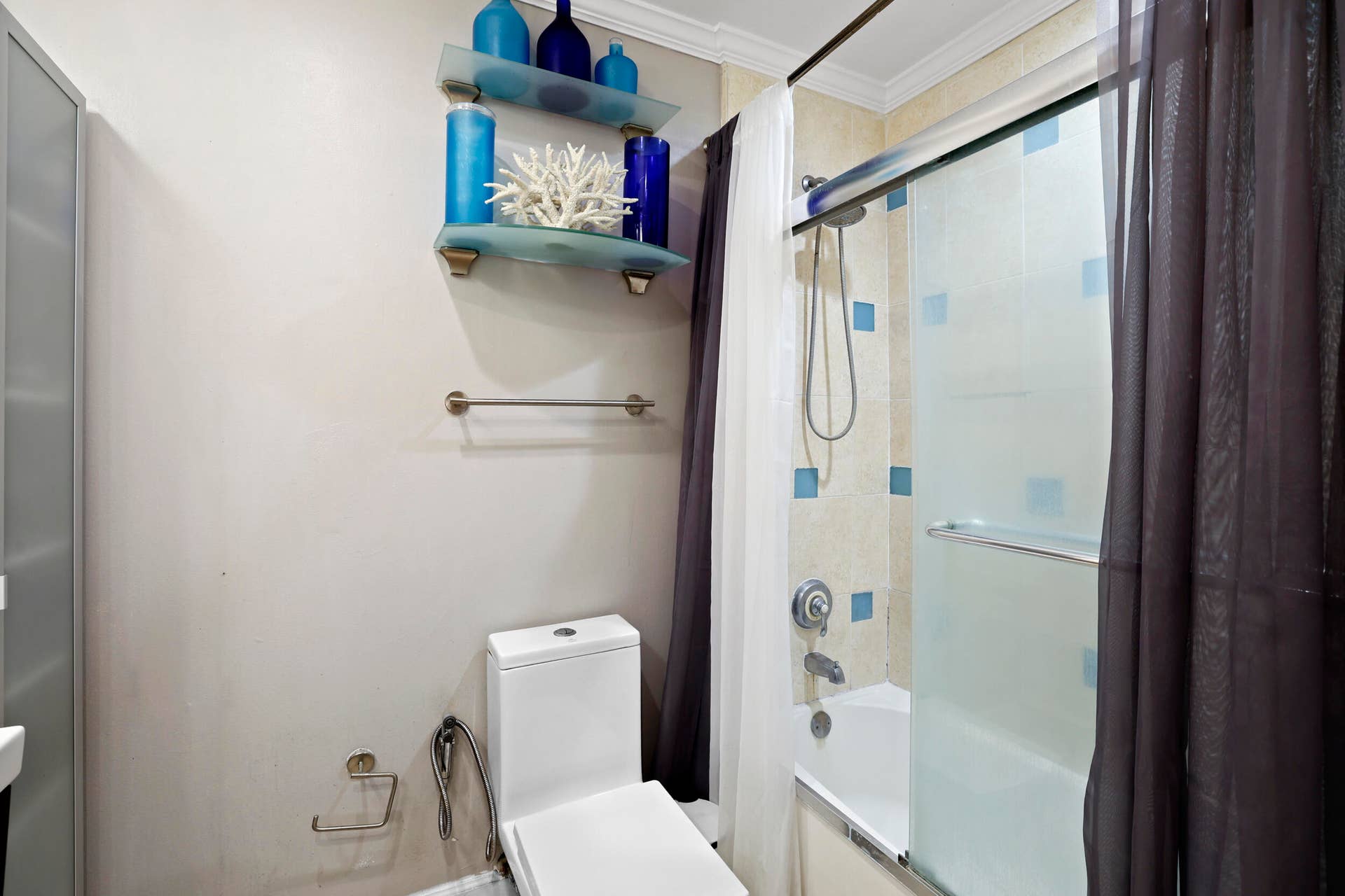 7 Middlesex Drive, Wilton Manors, FL 33305 Modern bathroom featuring a sleek glass-enclosed shower with tile surround and chrome fixtures, white porcelain toilet, towel bar, and brushed nickel hardware