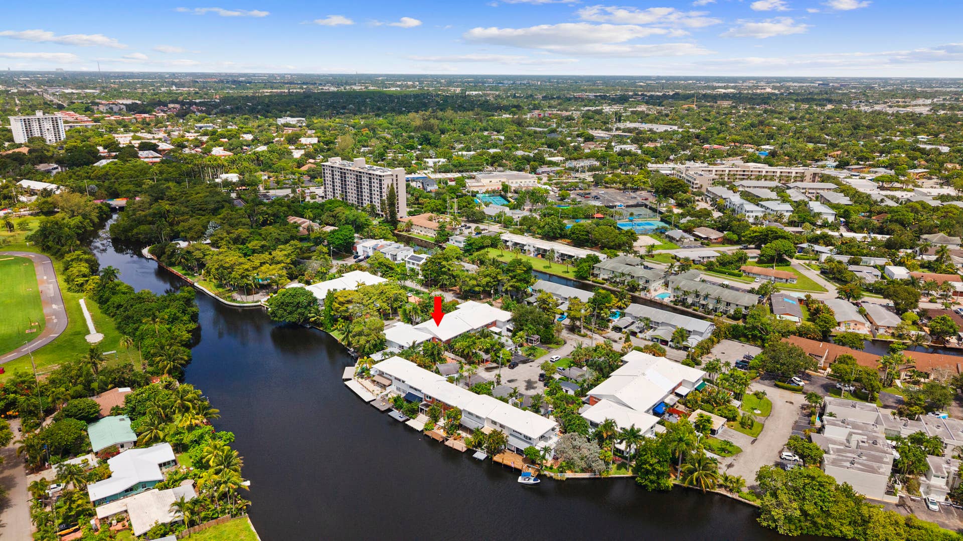 7 Middlesex Drive, Wilton Manors, FL 33305 Waterfront property featuring a canal, private boat docks, and lush surrounding foliage