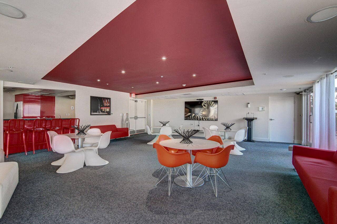 Spacious common area featuring recessed lighting, a red ceiling accent, and a built-in bar with seating
