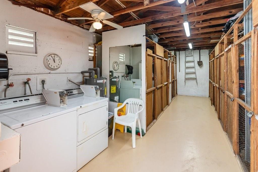2760 YACHT CLUB Boulevard, #10C, Fort Lauderdale, Fort Lauderdale, FL 33304 Utility and laundry room featuring commercial-grade washer and dryer, extensive wooden cabinetry and shelving along the perimeter, polished concrete flooring, exposed beam ceiling with integrated lighting, and direct access to a separate bathroom facility