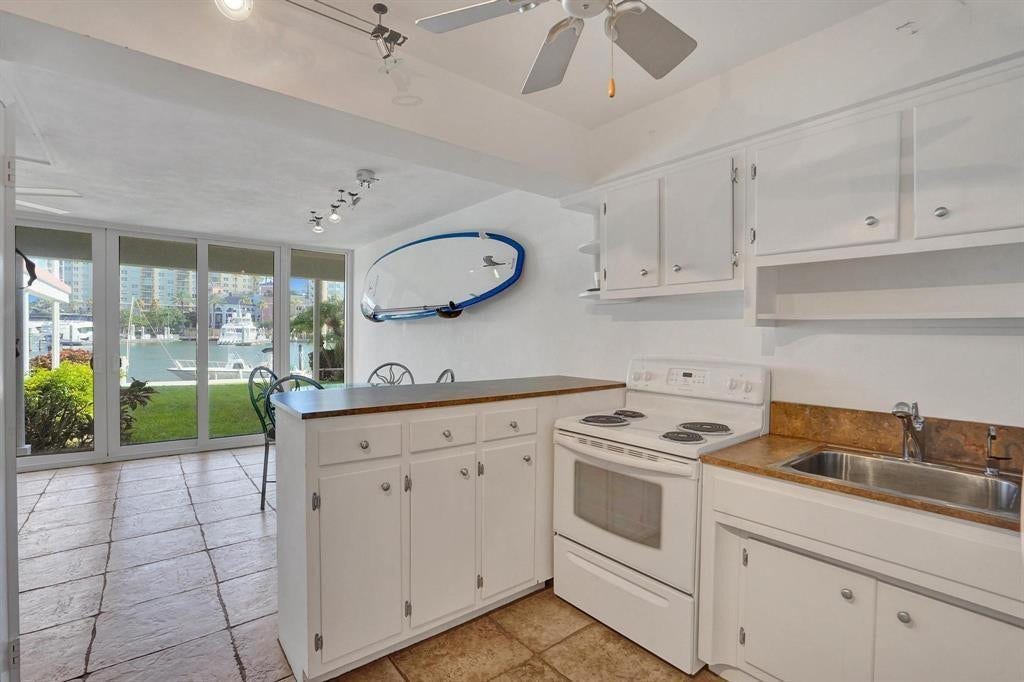 2760 YACHT CLUB Boulevard, #10C, Fort Lauderdale, Fort Lauderdale, FL 33304 Bright kitchen featuring white cabinetry with ample storage, wood-finish countertops, and stainless steel sink