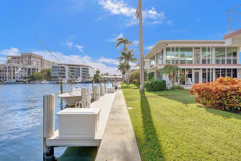 2760 YACHT CLUB Boulevard, #10C, Fort Lauderdale, Fort Lauderdale, FL 33304 Waterfront property featuring a private dock with multiple boat slips, a spacious green lawn, and mature palm trees