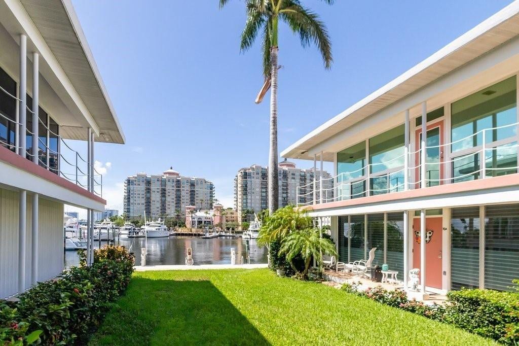 2760 YACHT CLUB Boulevard, #10C, Fort Lauderdale, Fort Lauderdale, FL 33304 Waterfront home featuring a manicured lawn with mature tropical landscaping, including towering palm trees and established hedging