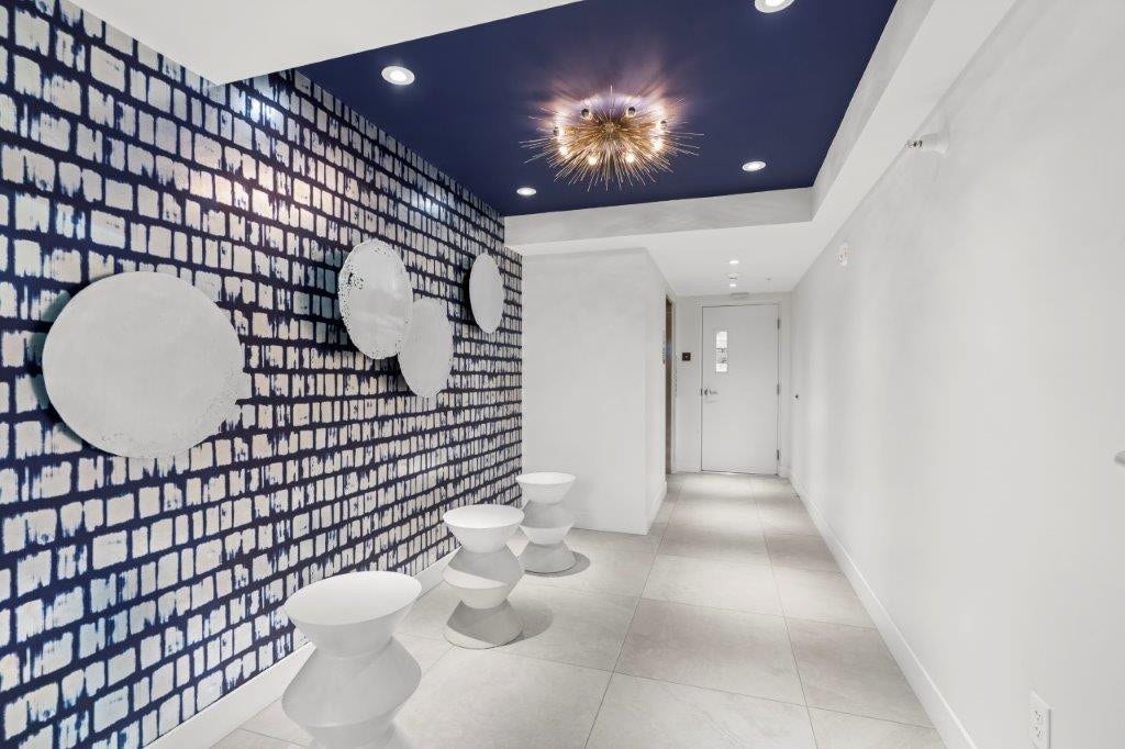 Entryway featuring a patterned accent wall, recessed lighting, and a dark blue ceiling