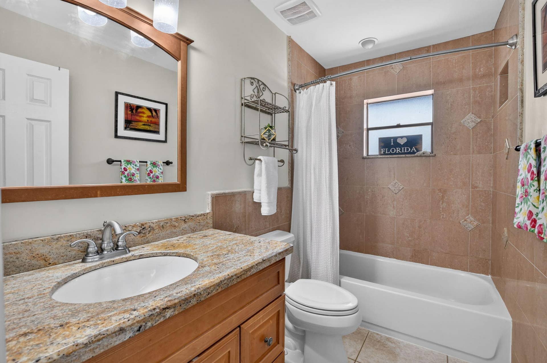 Guest bath with counter height vanity and tub/shower combination with inlays.