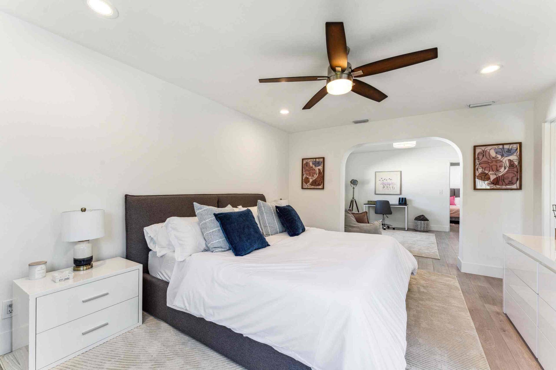 Spacious sleeping area featuring wood-finish flooring, recessed lighting, and a ceiling fan with integrated lighting