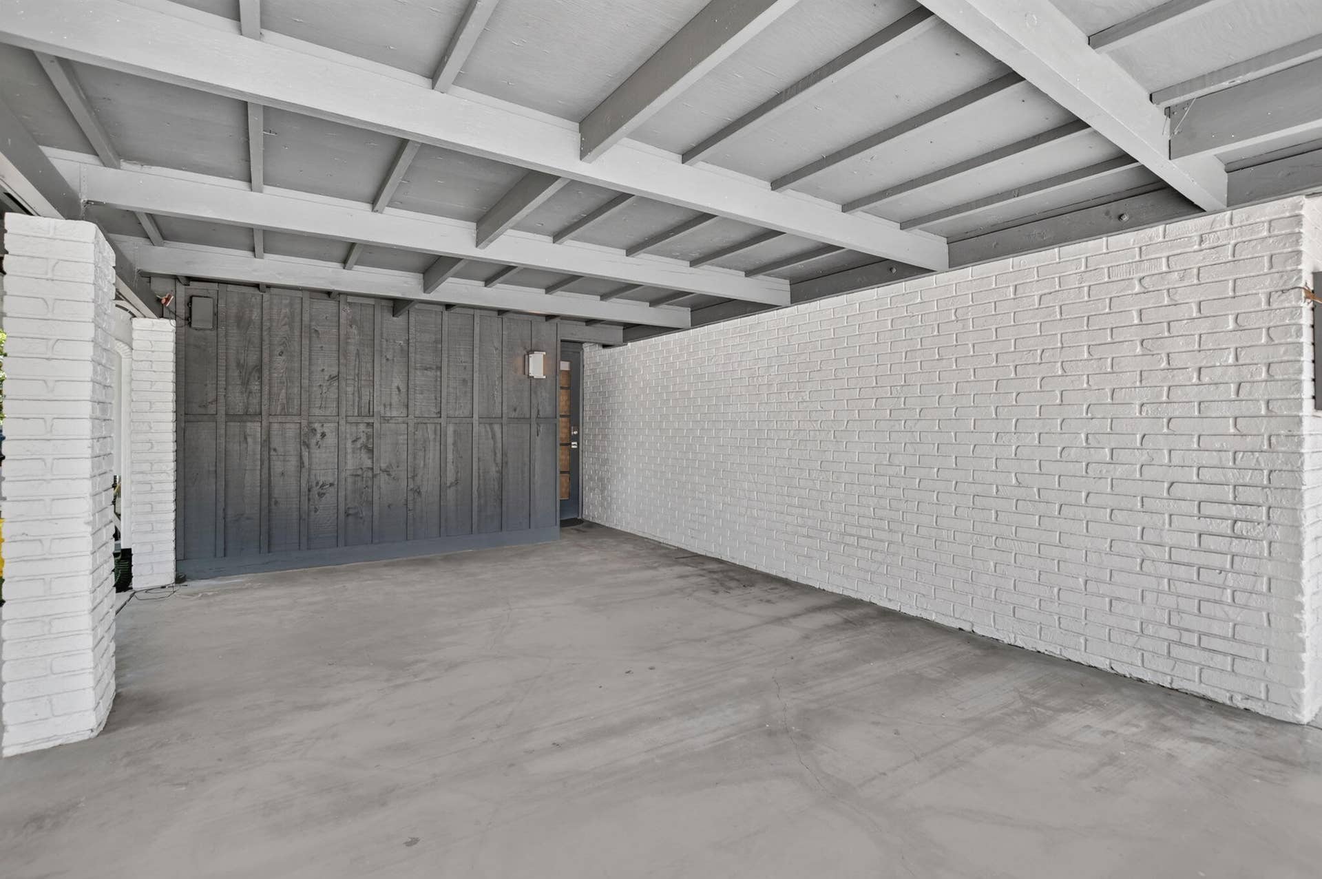 This oversized carport has plenty of room for a typical SUV with room to walk around the vehicle. It has lighting and an entrance door to the house. Perfect for rainy days! **NEWLY INSTALLED EV CHARGER**