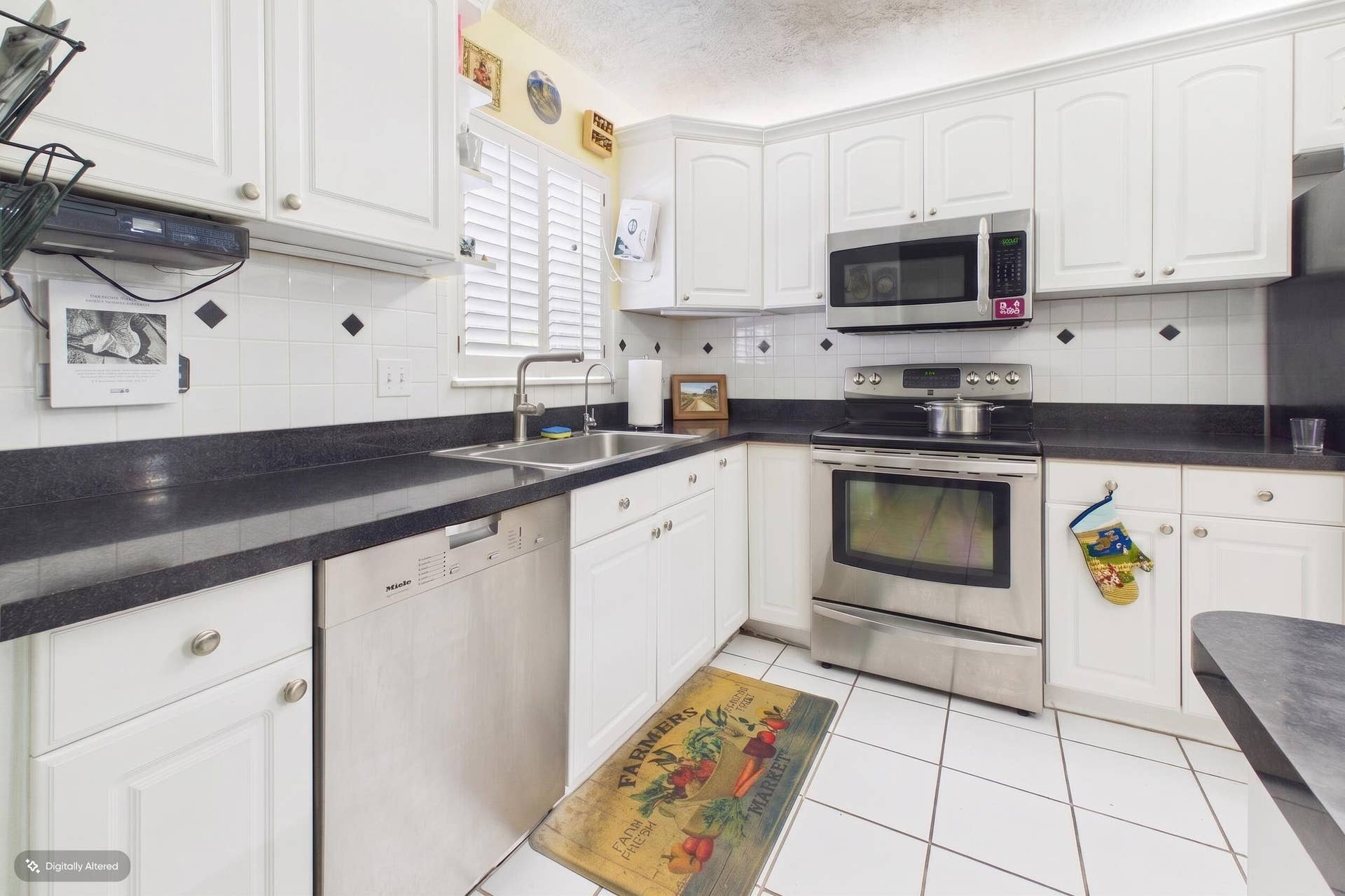 Kitchen with stainless steel appliances: electric range, microwave, and dishwasher.