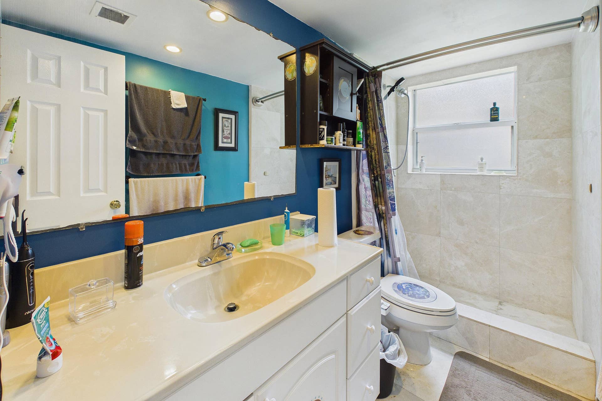 White vanity with integrated sink, chrome faucet, and storage cabinetry