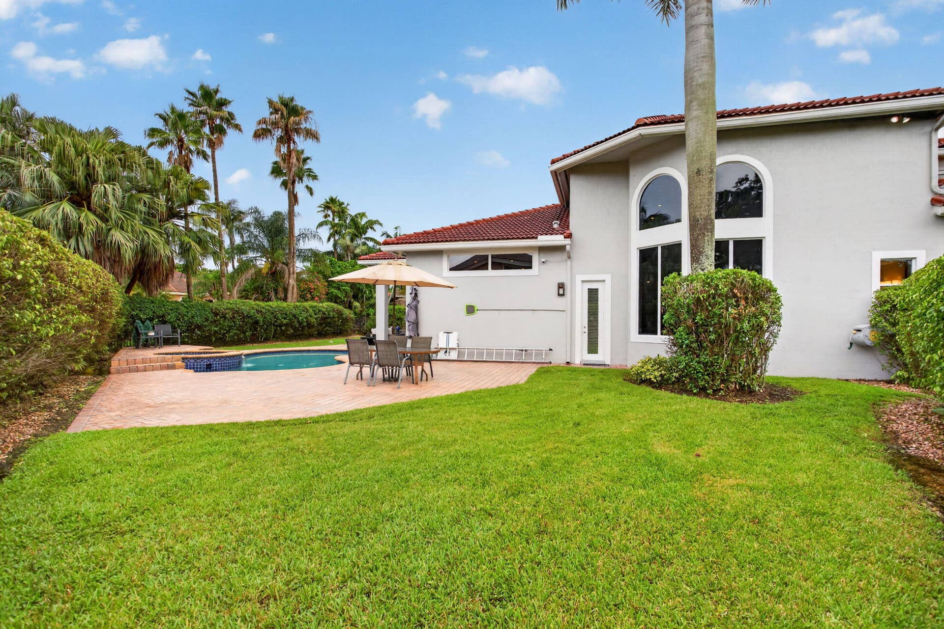 577 NW 120TH Drive, Coral Springs, FL 33071 Situated nearly on a half an acre , this fully fenced yard featuring a solar and gas heated pool, summer kitchen, spa, and yard space for endless activities