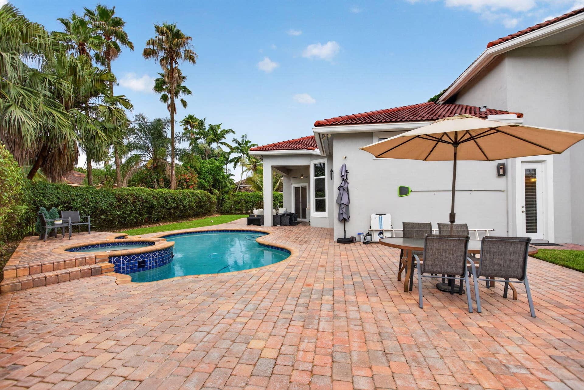 577 NW 120TH Drive, Coral Springs, FL 33071 Situated nearly on a half an acre , this fully fenced yard featuring a solar and gas heated pool, summer kitchen, spa, and yard space for endless activities