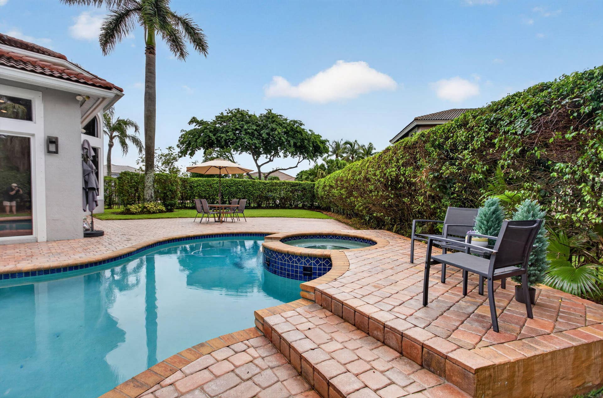 577 NW 120TH Drive, Coral Springs, FL 33071 Situated nearly on a half an acre , this fully fenced yard featuring a solar and gas heated pool, summer kitchen, spa, and yard space for endless activities