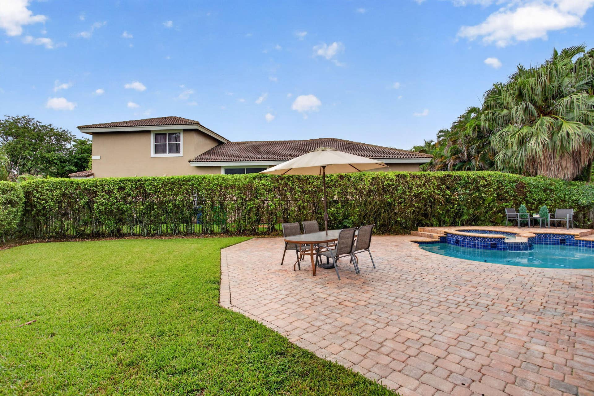 577 NW 120TH Drive, Coral Springs, FL 33071 Situated nearly on a half an acre , this fully fenced yard featuring a solar and gas heated pool, summer kitchen, spa, and yard space for endless activities