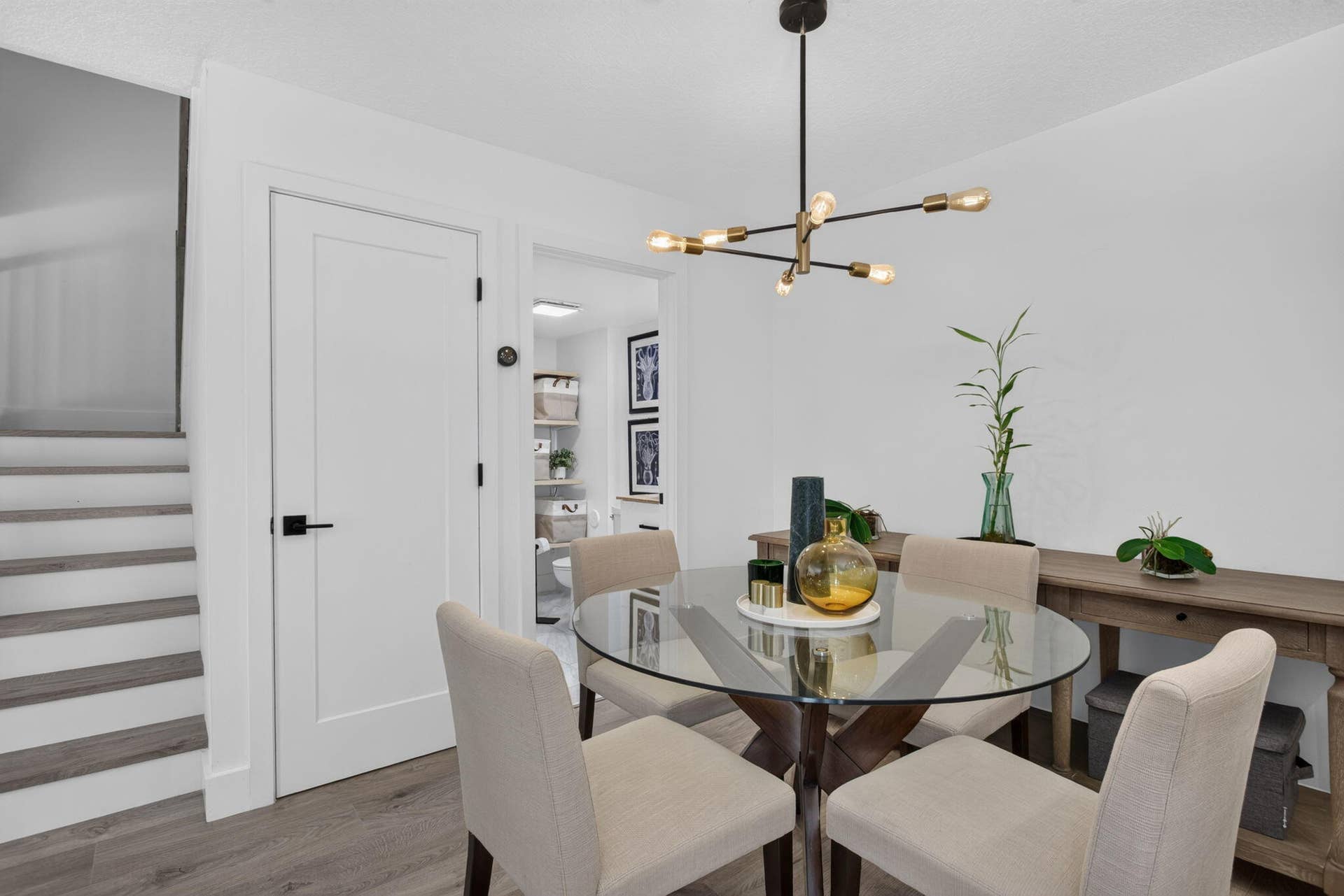 9113 SW 20th Court, #A, Davie, FL 33324 Modern chandelier with exposed bulbs, white interior walls, wood-finish flooring, and a contemporary flat-panel door with black hardware