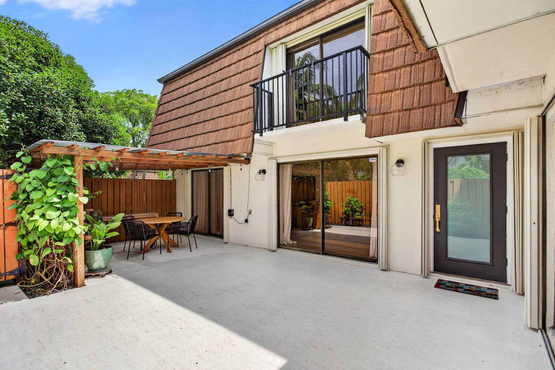 9113 SW 20th Court, #A, Davie, FL 33324 Spacious concrete patio featuring a wooden pergola and privacy fence