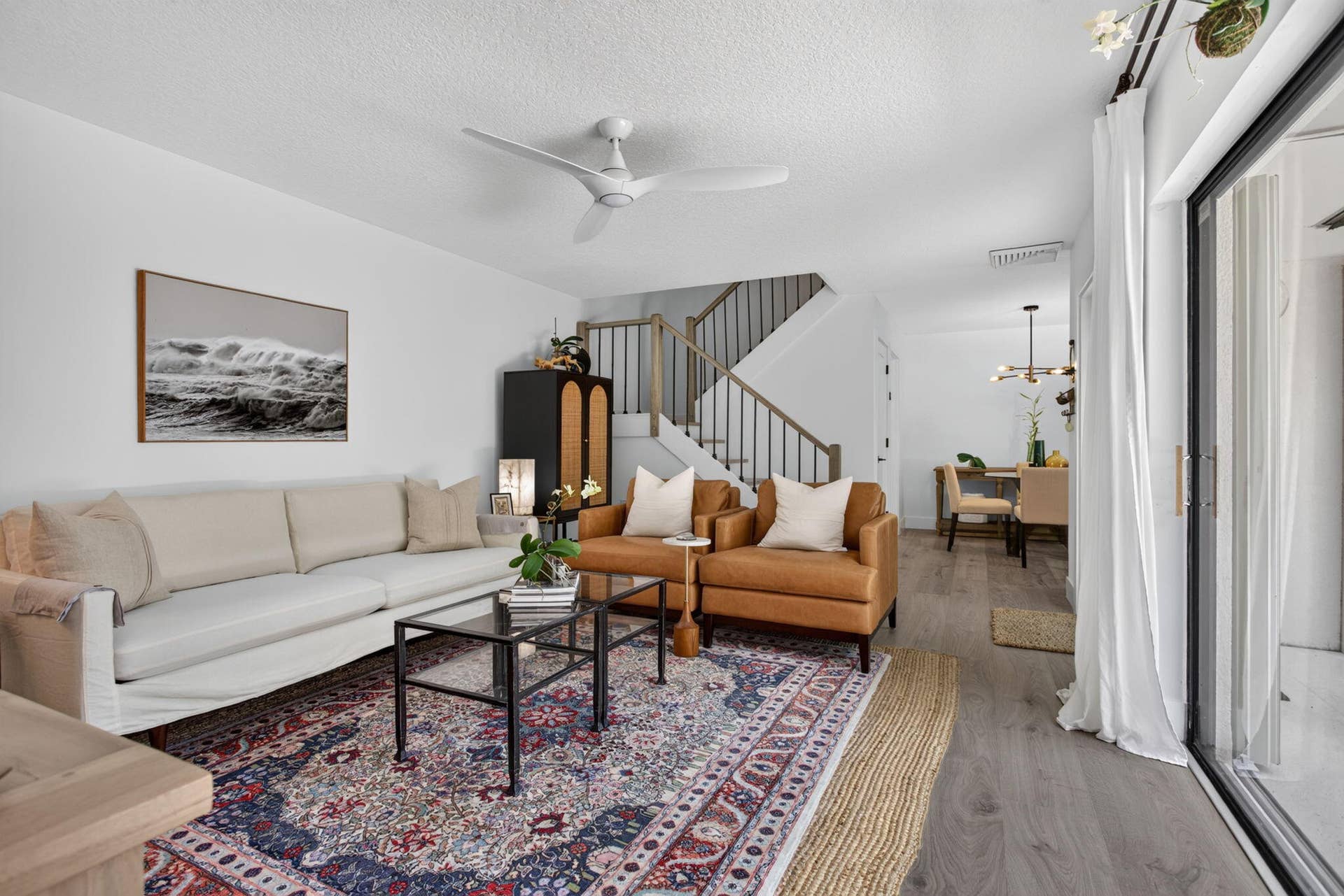 9113 SW 20th Court, #A, Davie, FL 33324 Open-concept living space featuring wood-finish flooring, a contemporary ceiling fan, and sliding glass doors