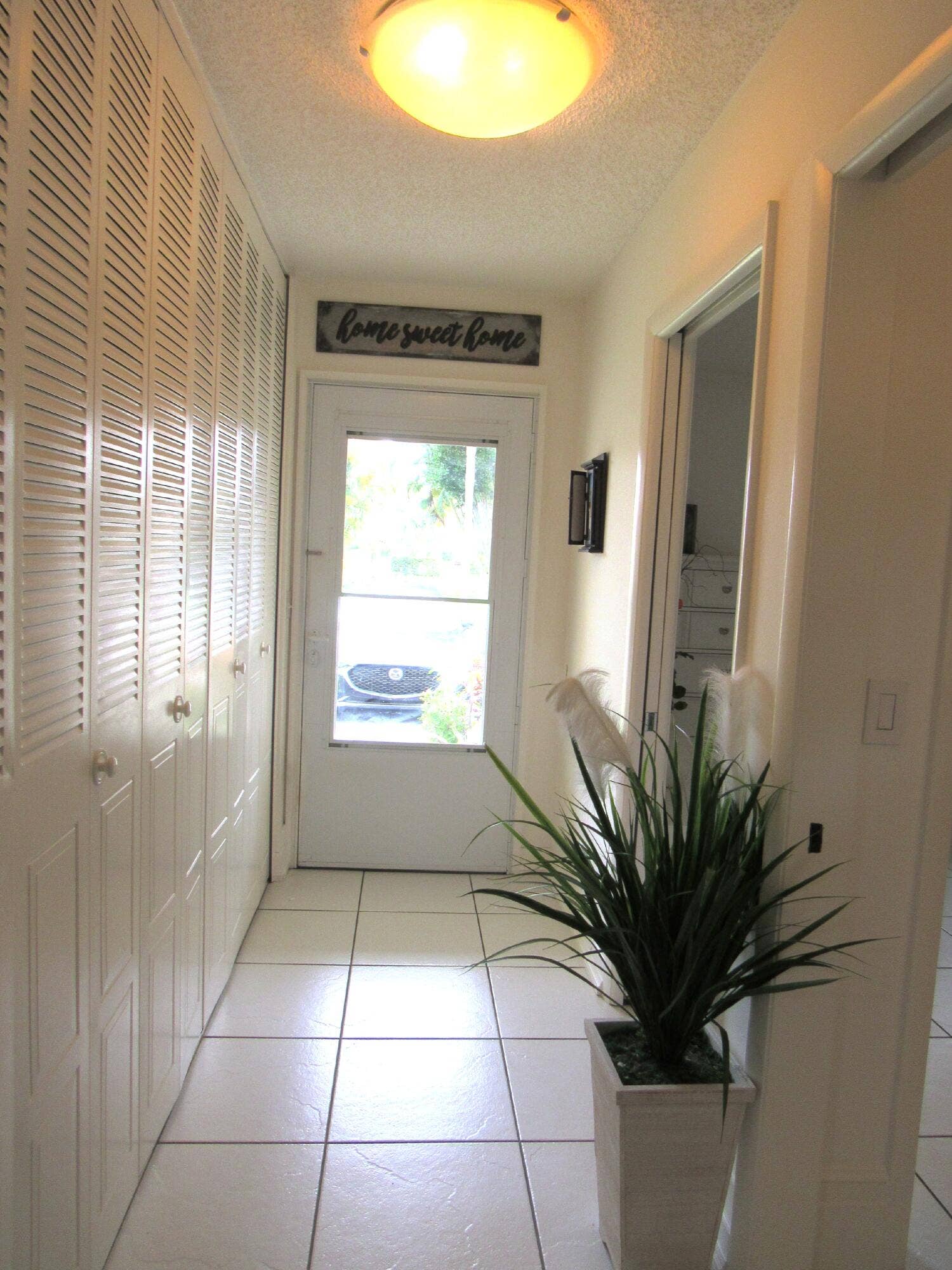 White tile flooring, louvered closet doors, and recessed lighting