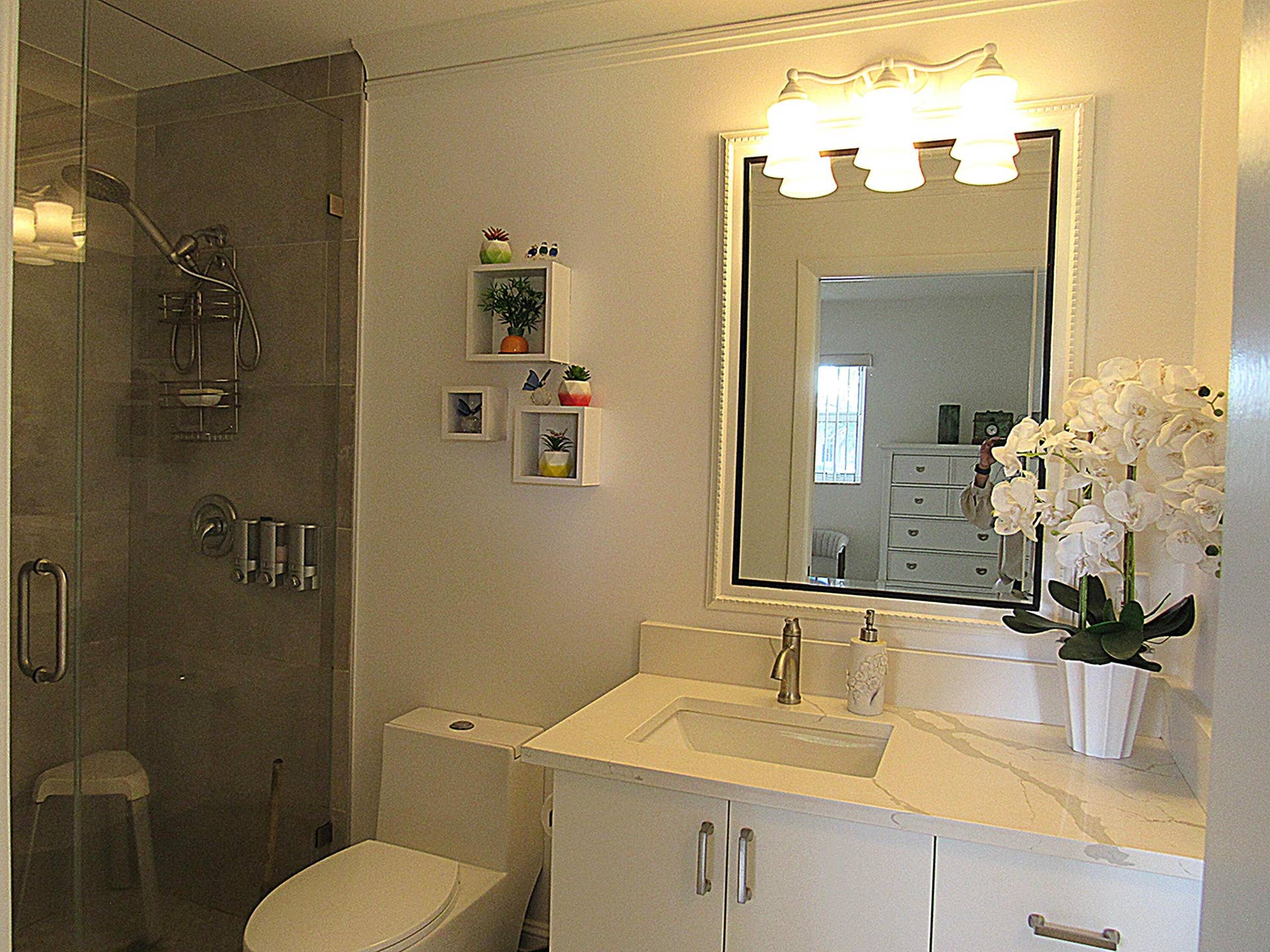 Glass-enclosed shower with tiled walls and an integrated showerhead