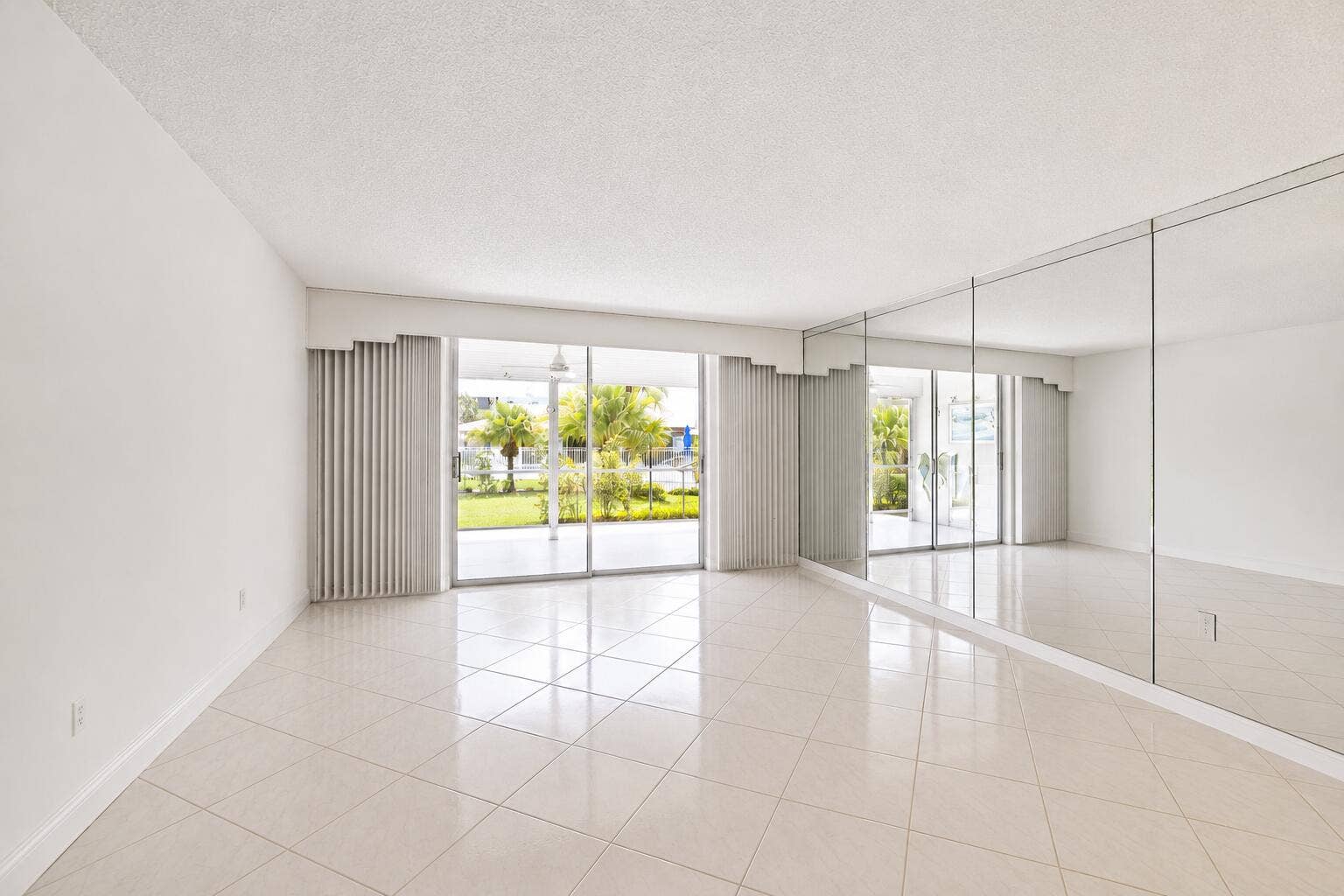 Bright, open living space flooded with natural light through expansive glass doors and windows