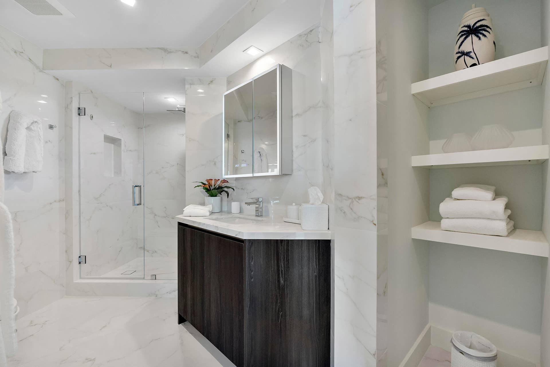 1700 S OCEAN Boulevard, #PH B-D, Lauderdale By The Sea, FL 33062 A Private Spa Bath for the Guest Wing Completing the accommodations is a beautifully appointed en-suite bath, finished in luminous marble-inspired surfaces with an expansive vanity, illuminated mirror, glass-enclosed shower and elegant built-in display and linen shelving. Spacious, serene and completely private, it gives guests the comfort and convenience of a luxury hotel suite while remaining within the intimacy of the residence.