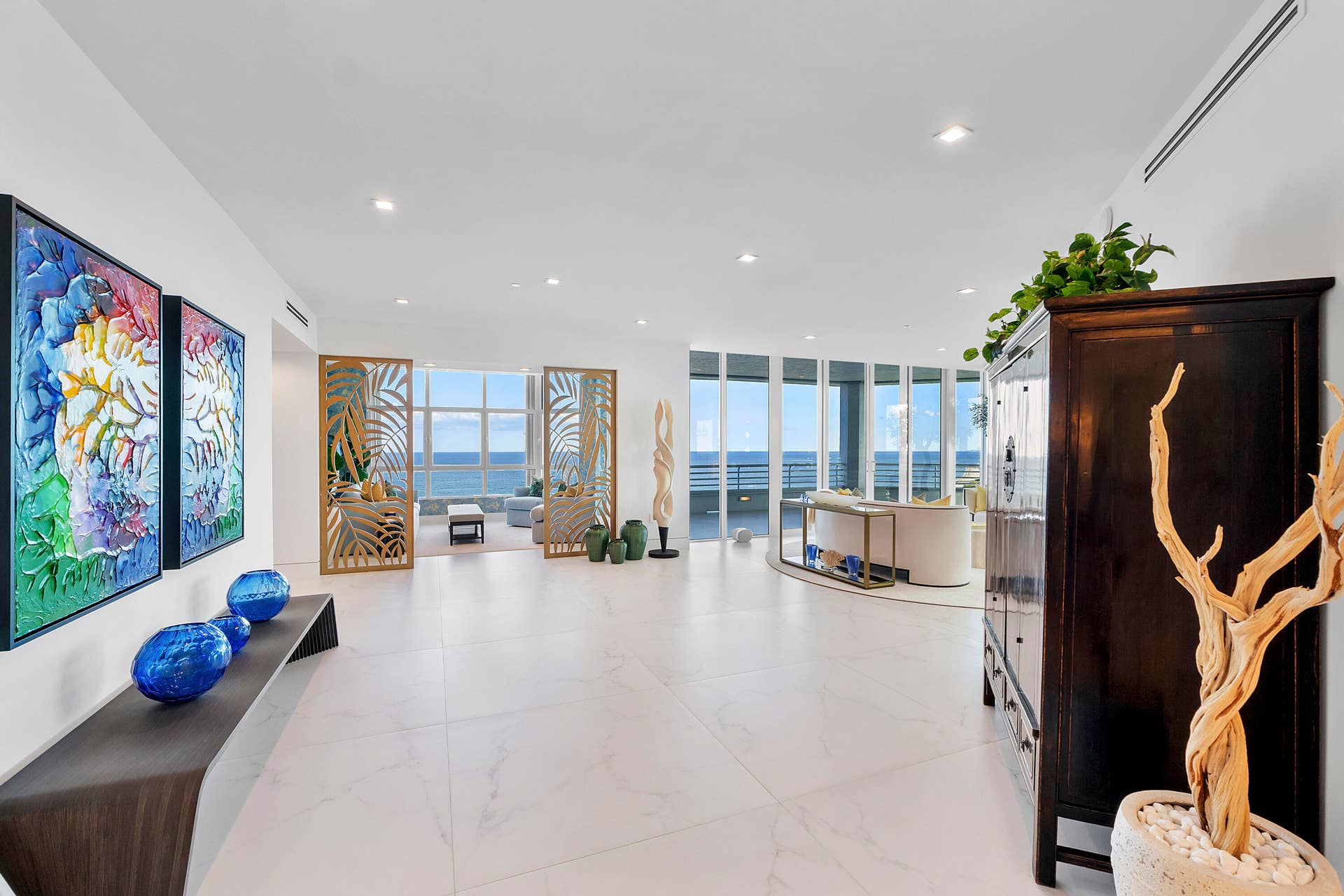 1700 S OCEAN Boulevard, #PH B-D, Lauderdale By The Sea, FL 33062 A statement sculpture commands the center of the gallery, allowing the artwork to be experienced from every angle as the gallery curves gracefully toward the Great Entertainment Room.As you round the gallery-inspired hallway, the residence unfolds into a spectacular grand entertaining salon where family and friends naturally gather against a breathtaking backdrop of the Atlantic Ocean. Floor-to-ceiling walls of glass frame uninterrupted sapphire-blue waters, pristine sandy beaches, and spectacular vistas stretching south toward the Miami skyline. Curated designer artwork, statement sculptures, bespoke furnishings, and architectural accents transform this magnificent space into a private showcase of contemporary elegance, where every detail has been thoughtfully selected and is included with the residence.
