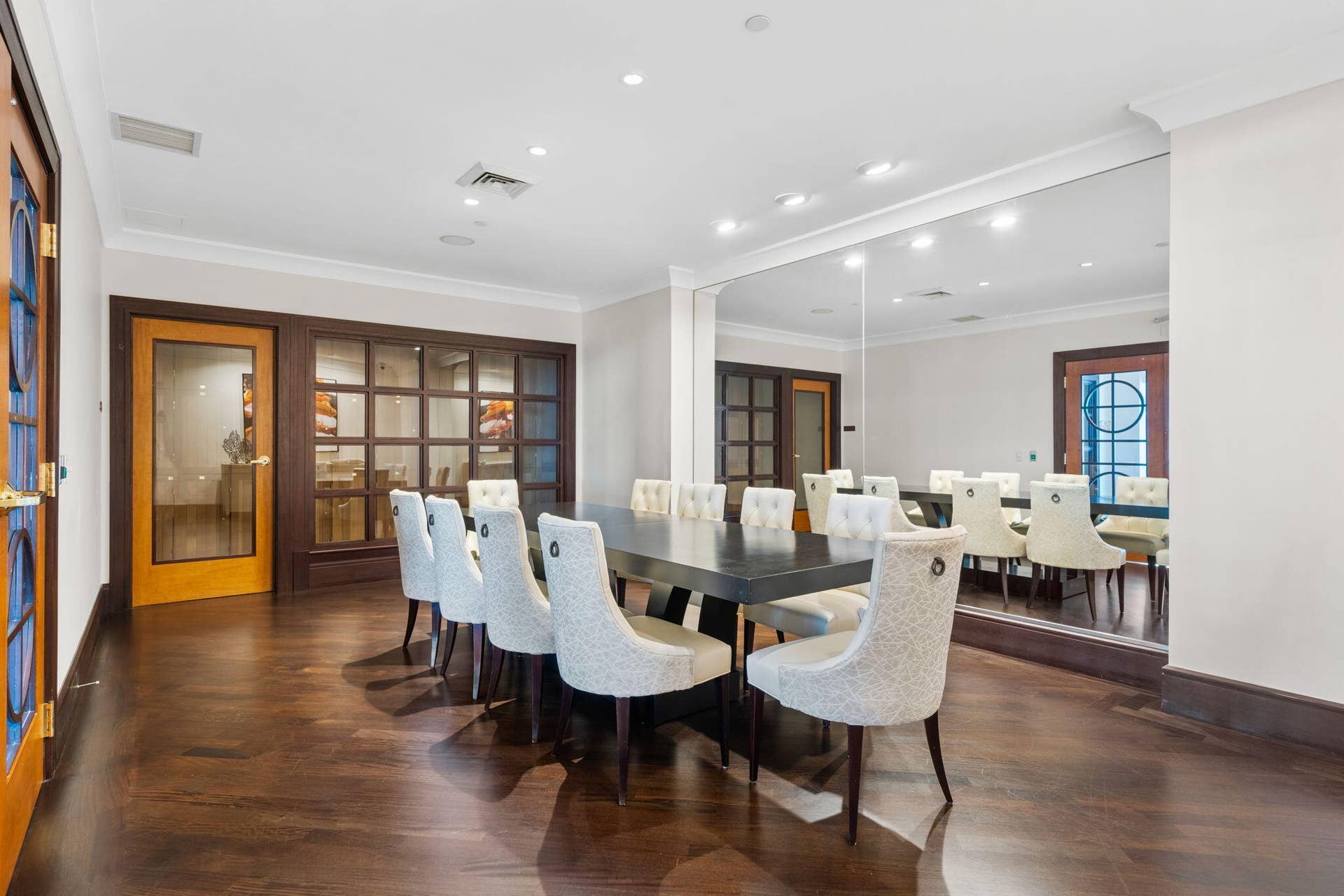 600 W LAS OLAS Boulevard, #902S, Fort Lauderdale, FL 33312 Private wine tasting room with a communal table, refined seating & mirrored wall detail for intimate gatherings.