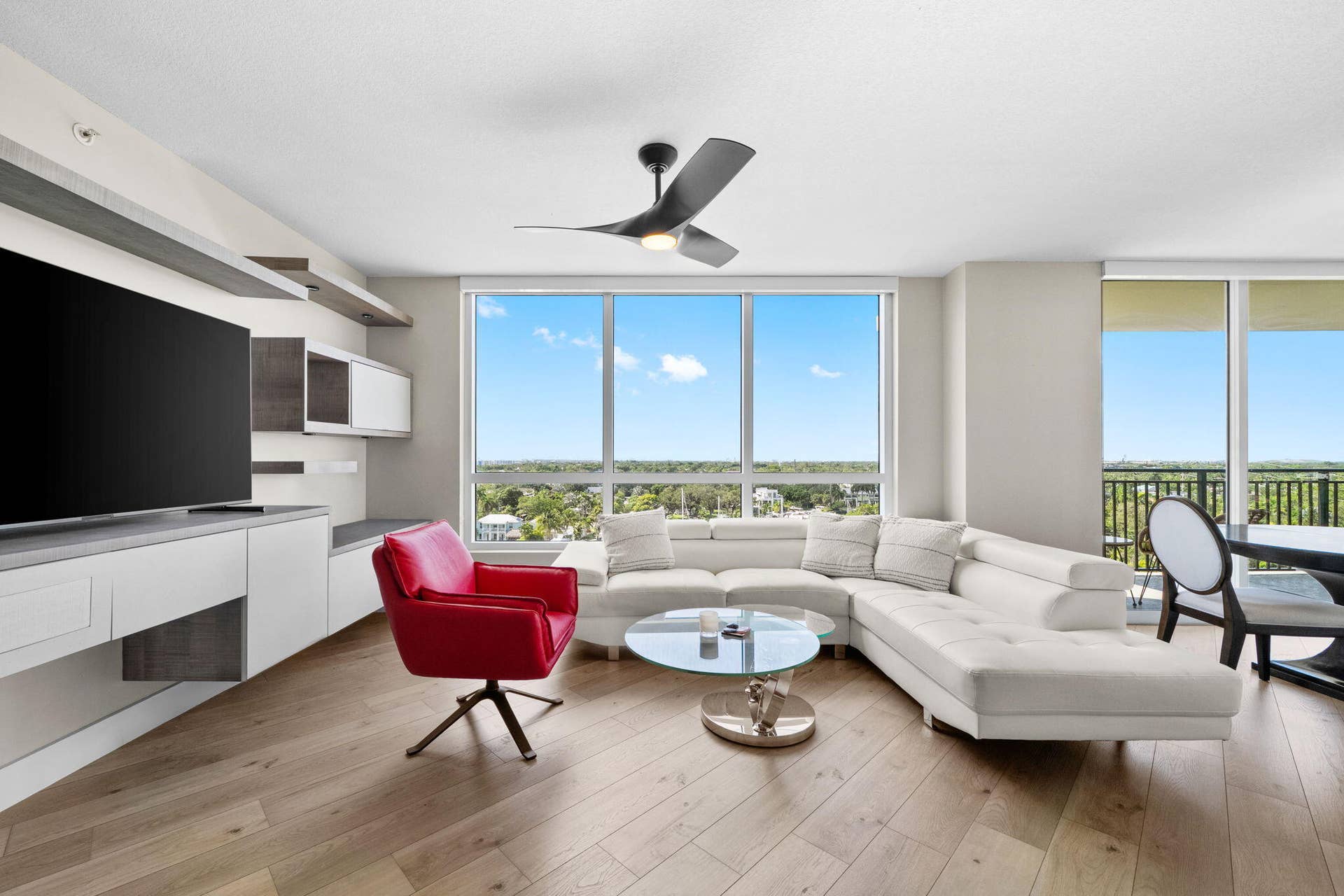 600 W LAS OLAS Boulevard, #902S, Fort Lauderdale, FL 33312 Spacious furnished living room with a large sectional sofa, accent chair, custom built-in media wall & broad southwest views across Fort Lauderdale.