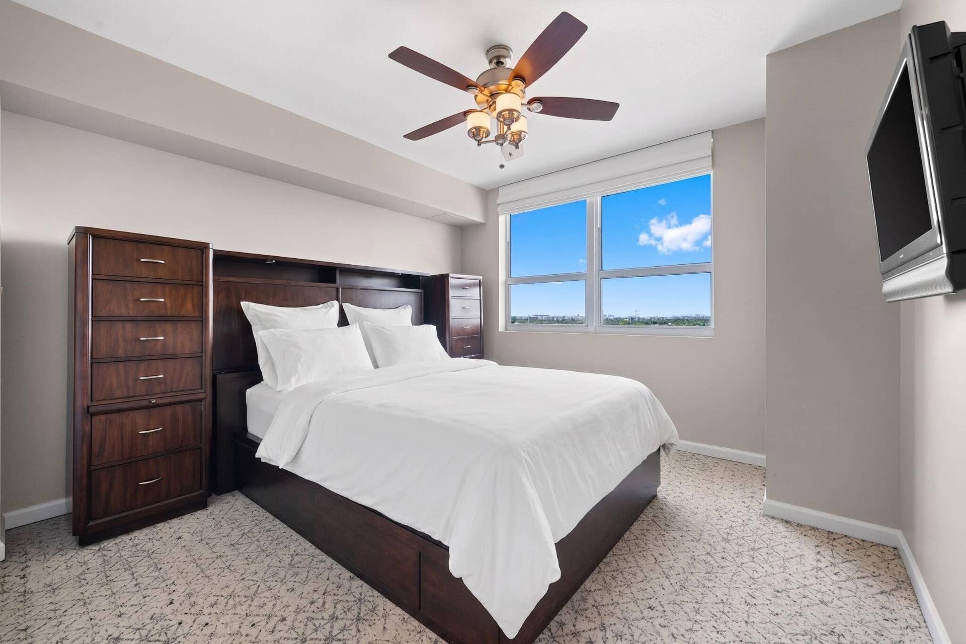 600 W LAS OLAS Boulevard, #902S, Fort Lauderdale, FL 33312 Furnished second bedroom with bed, built-in storage cabinetry, television, ceiling fan & large window with open views.