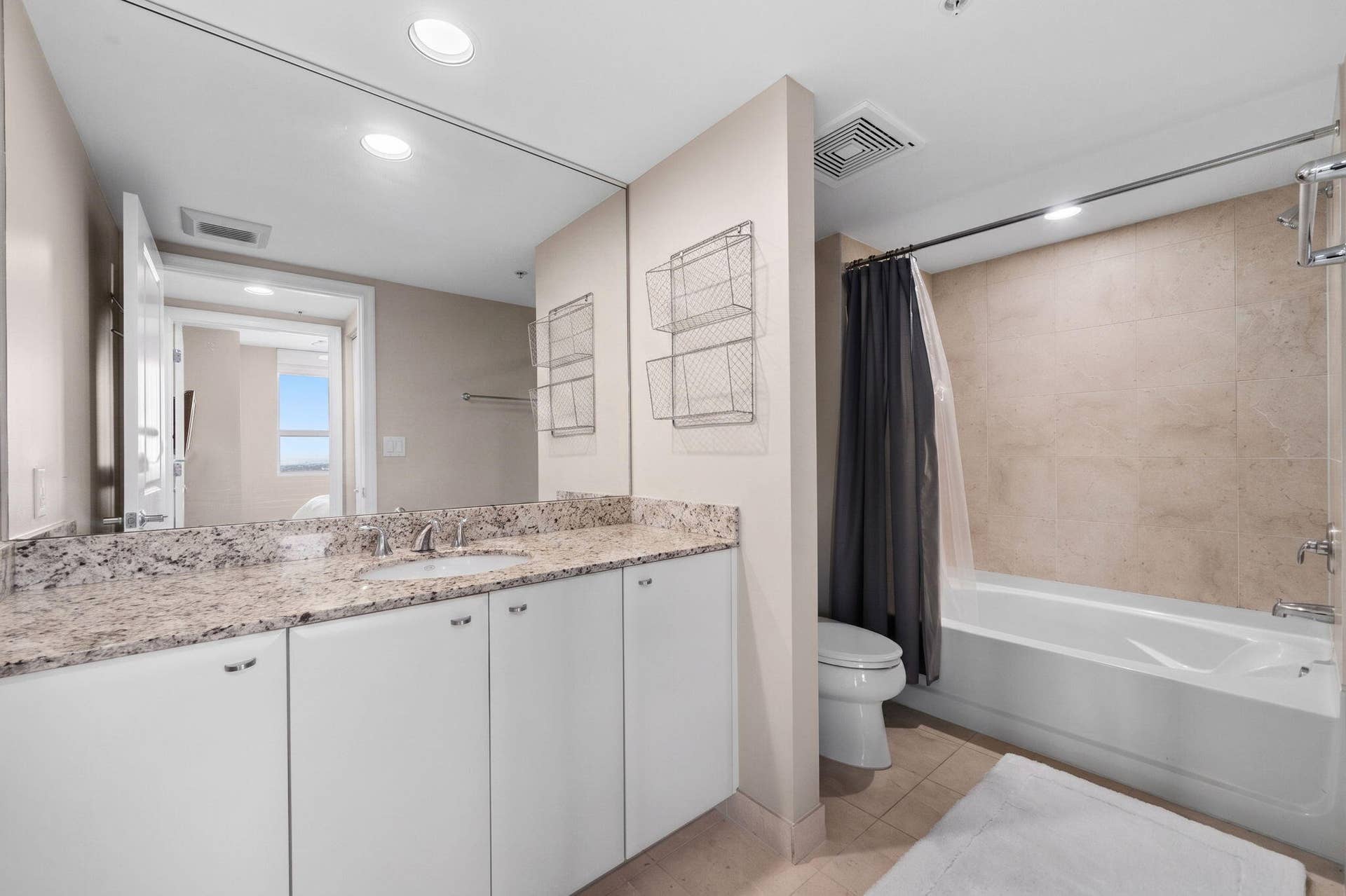 600 W LAS OLAS Boulevard, #902S, Fort Lauderdale, FL 33312 Second full bathroom with granite vanity, large mirrored wall & tub/shower combination with neutral tile surround.
