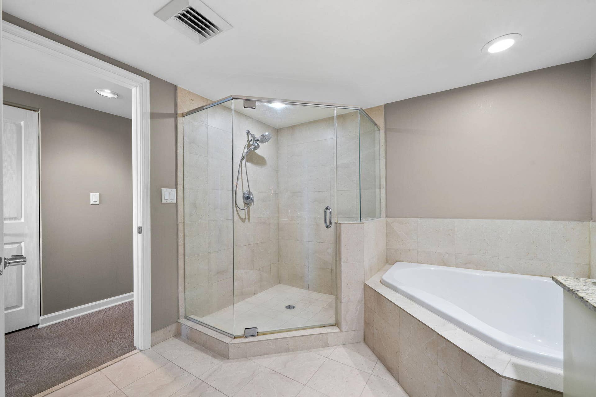 600 W LAS OLAS Boulevard, #902S, Fort Lauderdale, FL 33312 Primary bath featuring a separate glass-enclosed walk-in shower, oversized soaking tub & neutral tile finishes.