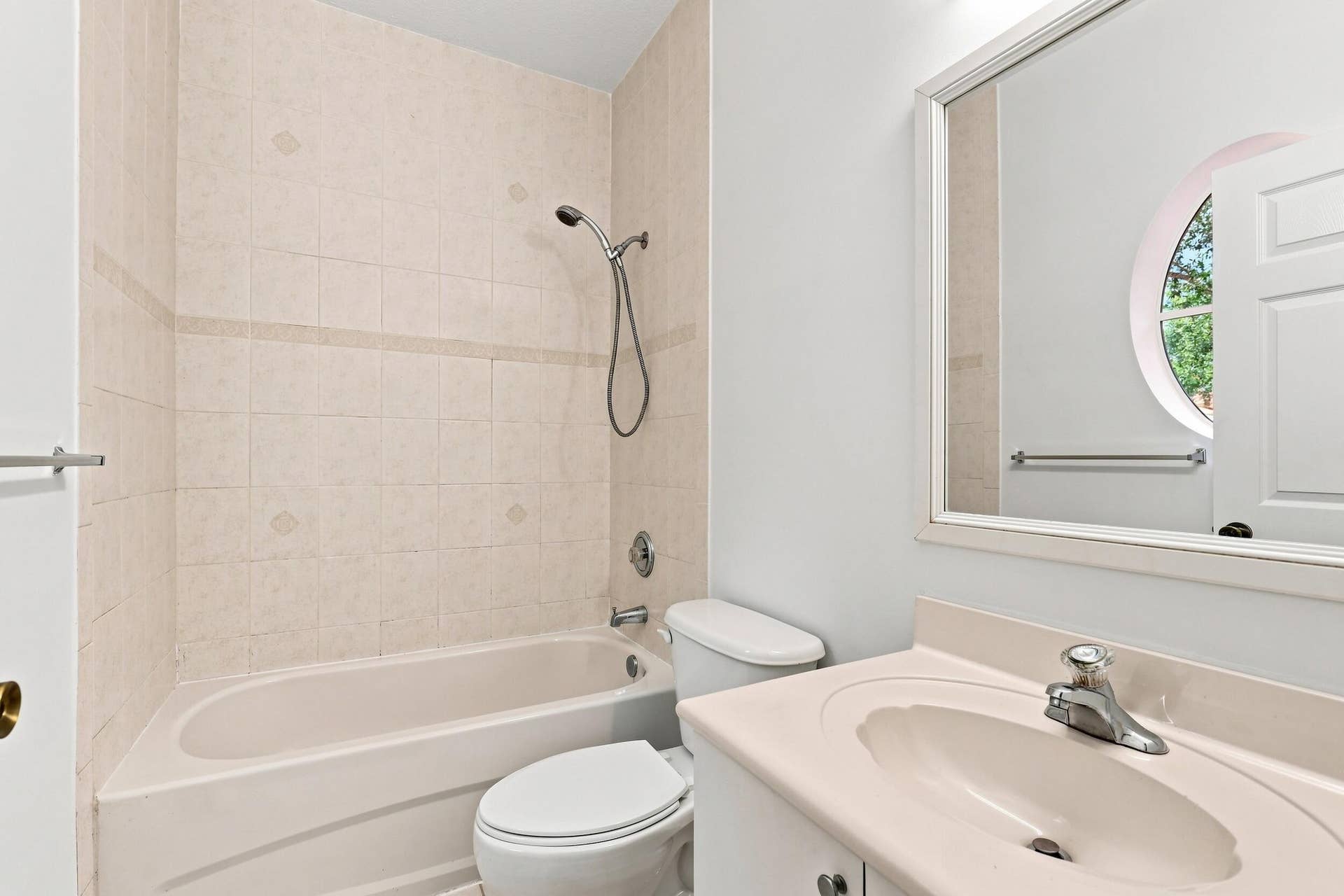 2107 Anchor Court, Fort Lauderdale, FL 33312 Private ensuite full bathroom featuring a tub and shower combination with tiled surround, vanity, and natural light from a distinctive round window.