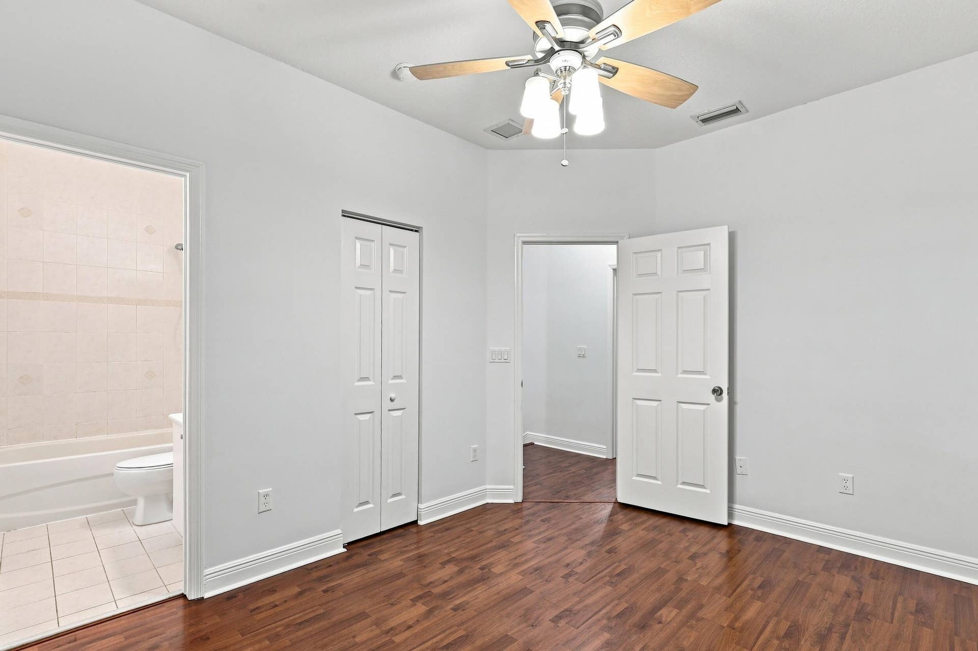 2107 Anchor Court, Fort Lauderdale, FL 33312 Spacious guest bedroom with wood flooring, ceiling fan, generous closet space, natural light, and a private ensuite full bathroom.