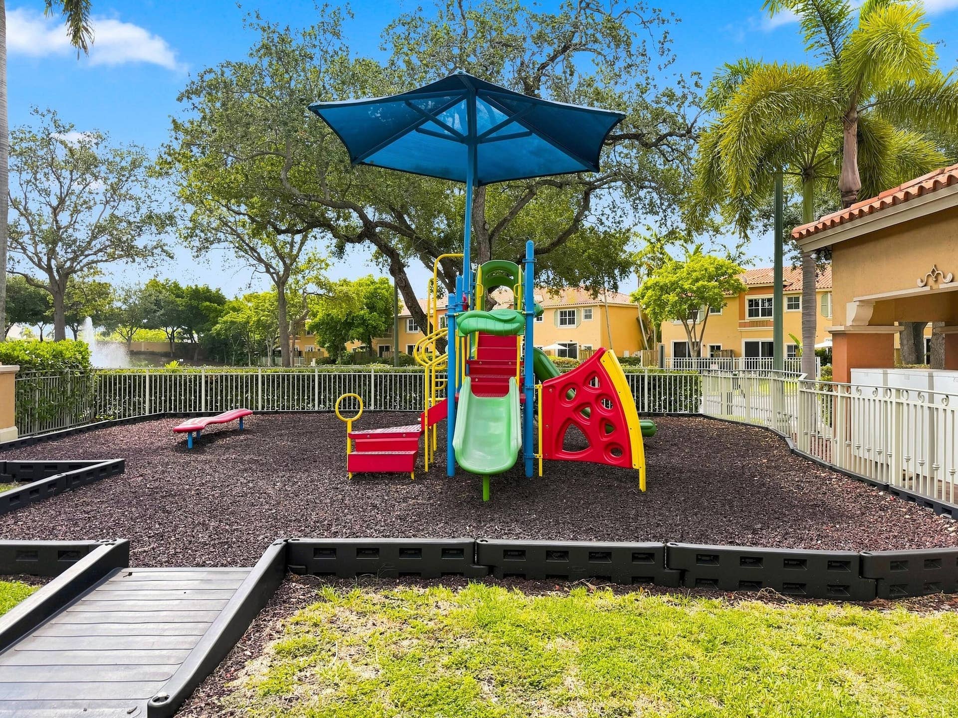 2107 Anchor Court, Fort Lauderdale, FL 33312 Colorful community playground with shaded play equipment, surrounded by mature landscaping and peaceful water views.