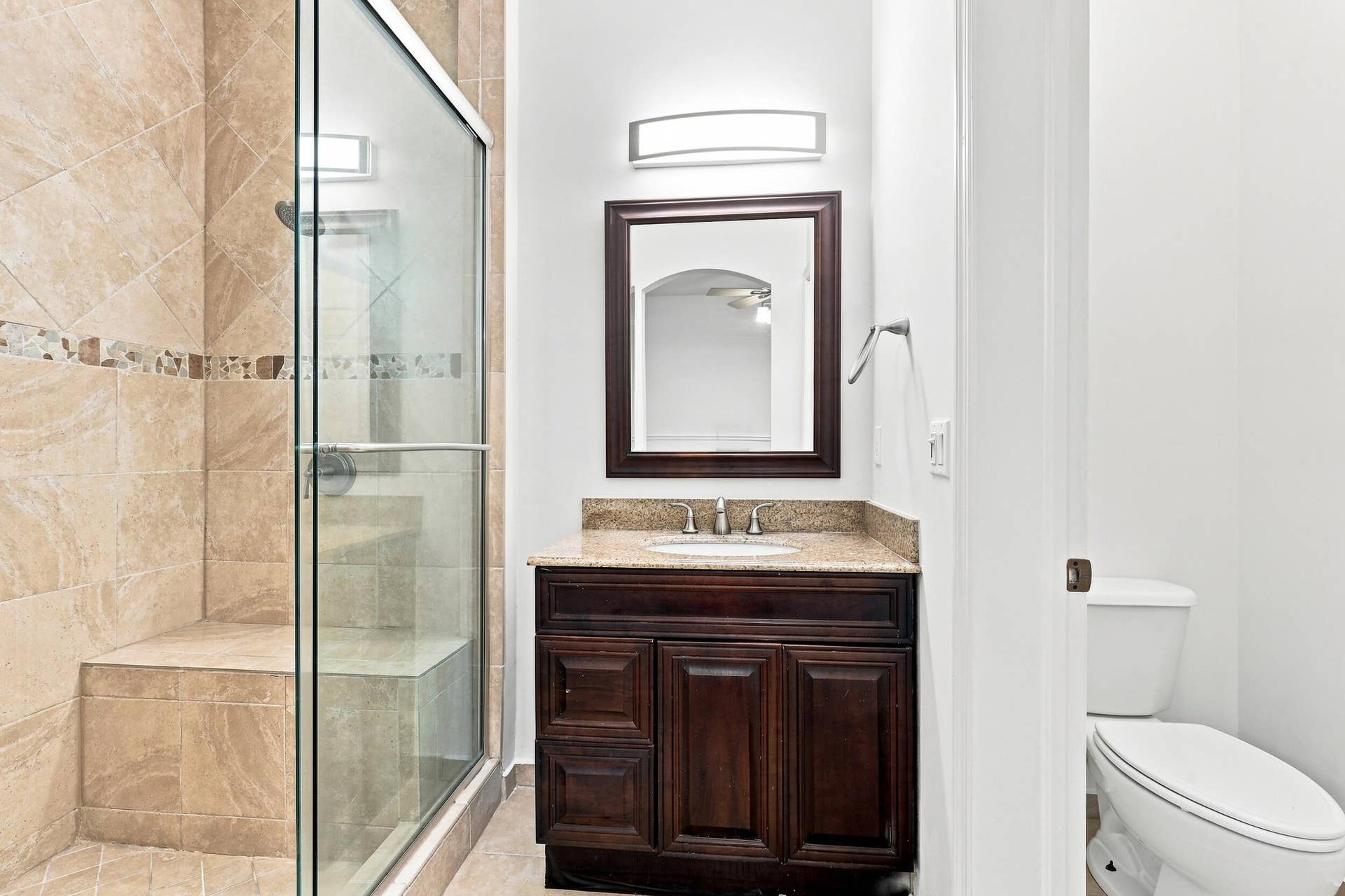 2107 Anchor Court, Fort Lauderdale, FL 33312 Private primary bathroom featuring a spacious walk in shower with floor to ceiling tile, frameless glass enclosure, built in bench, handheld showerhead, granite topped vanity, and a separate water closet.