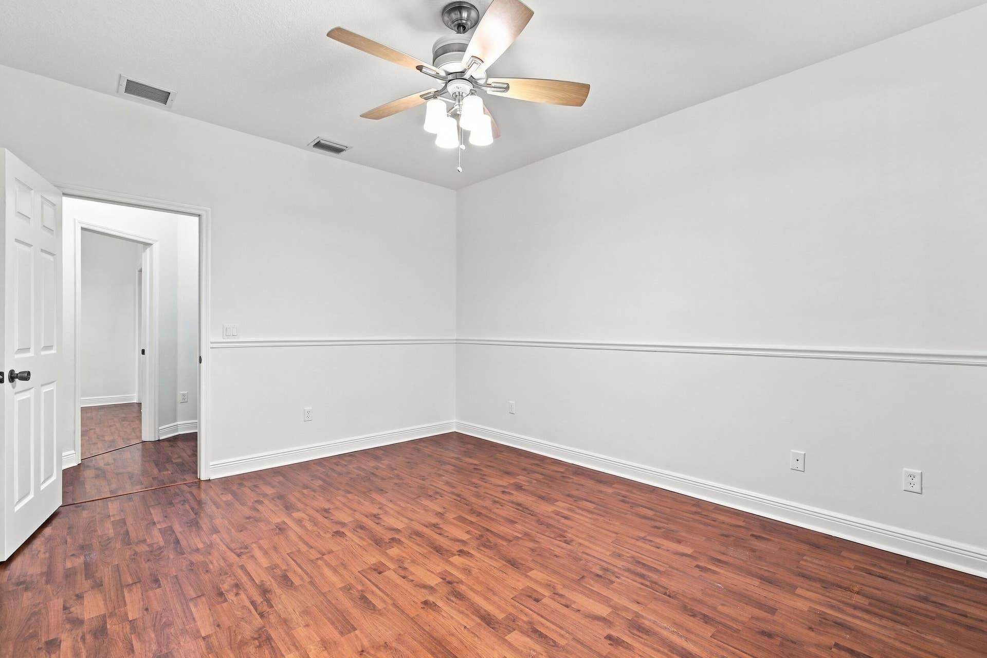 2107 Anchor Court, Fort Lauderdale, FL 33312 Spacious primary suite featuring warm wood flooring, abundant natural light, a large window overlooking lush greenery, and direct access to the private ensuite bathroom. The generous layout provides plenty of space and creates a comfortable private retreat.