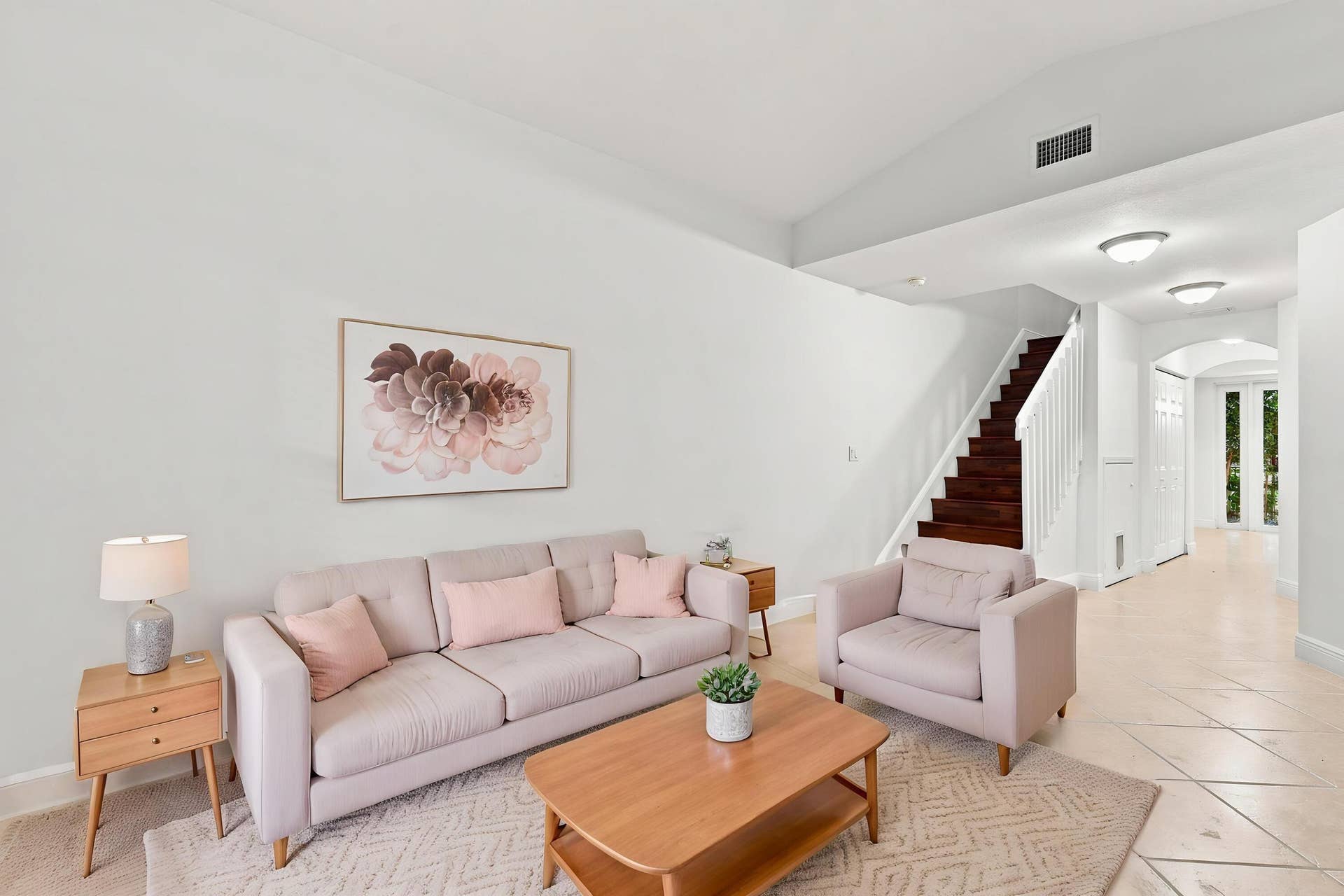 2107 Anchor Court, Fort Lauderdale, FL 33312 Spacious living area just off the front entry featuring tile flooring, high ceilings, and an open layout that flows seamlessly toward the kitchen and dining areas. A wood staircase adds warmth and character while leading to the second floor.