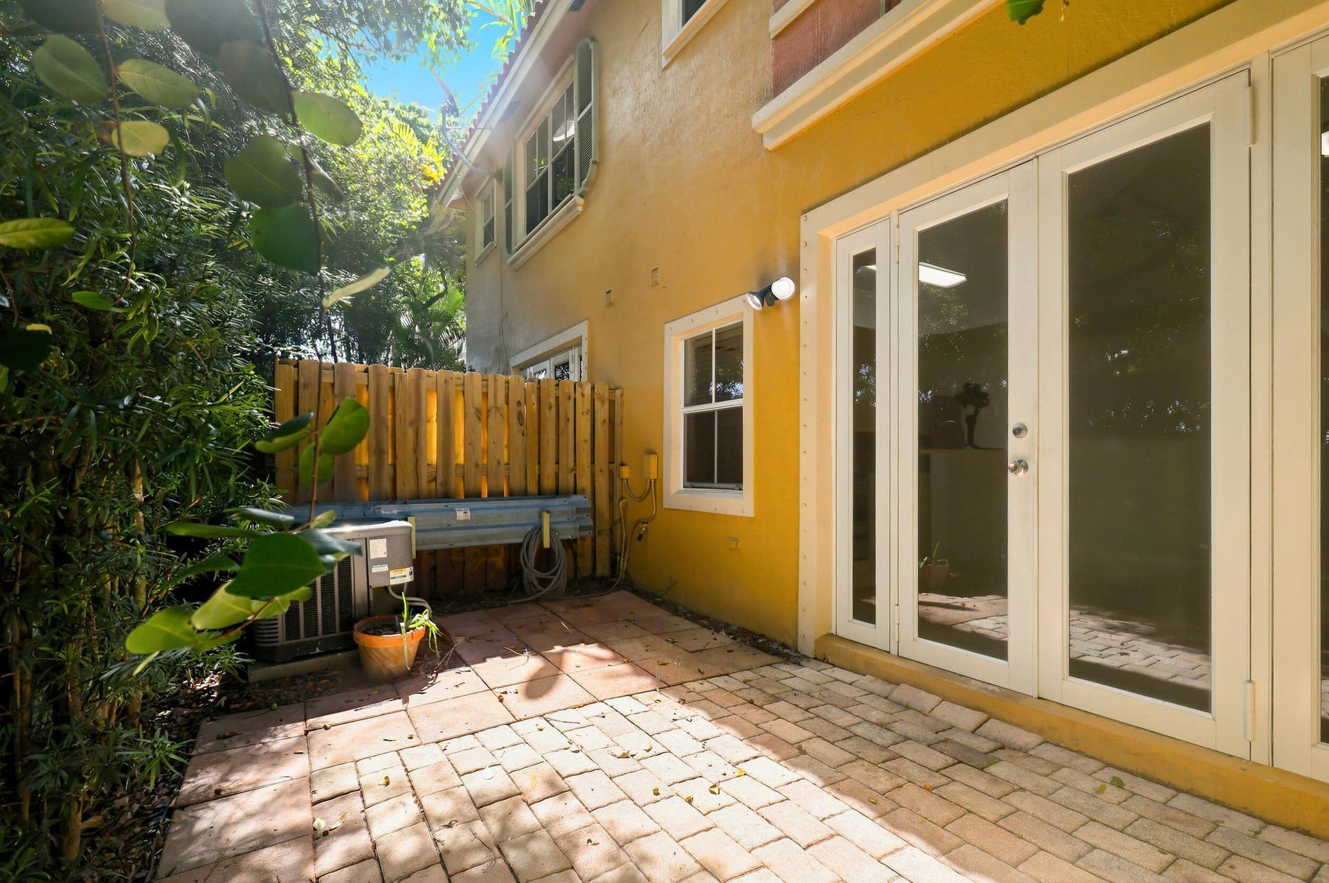 2107 Anchor Court, Fort Lauderdale, FL 33312 Private brick-paver patio surrounded by mature tropical landscaping, offering a peaceful, shaded outdoor space with direct access from the home.