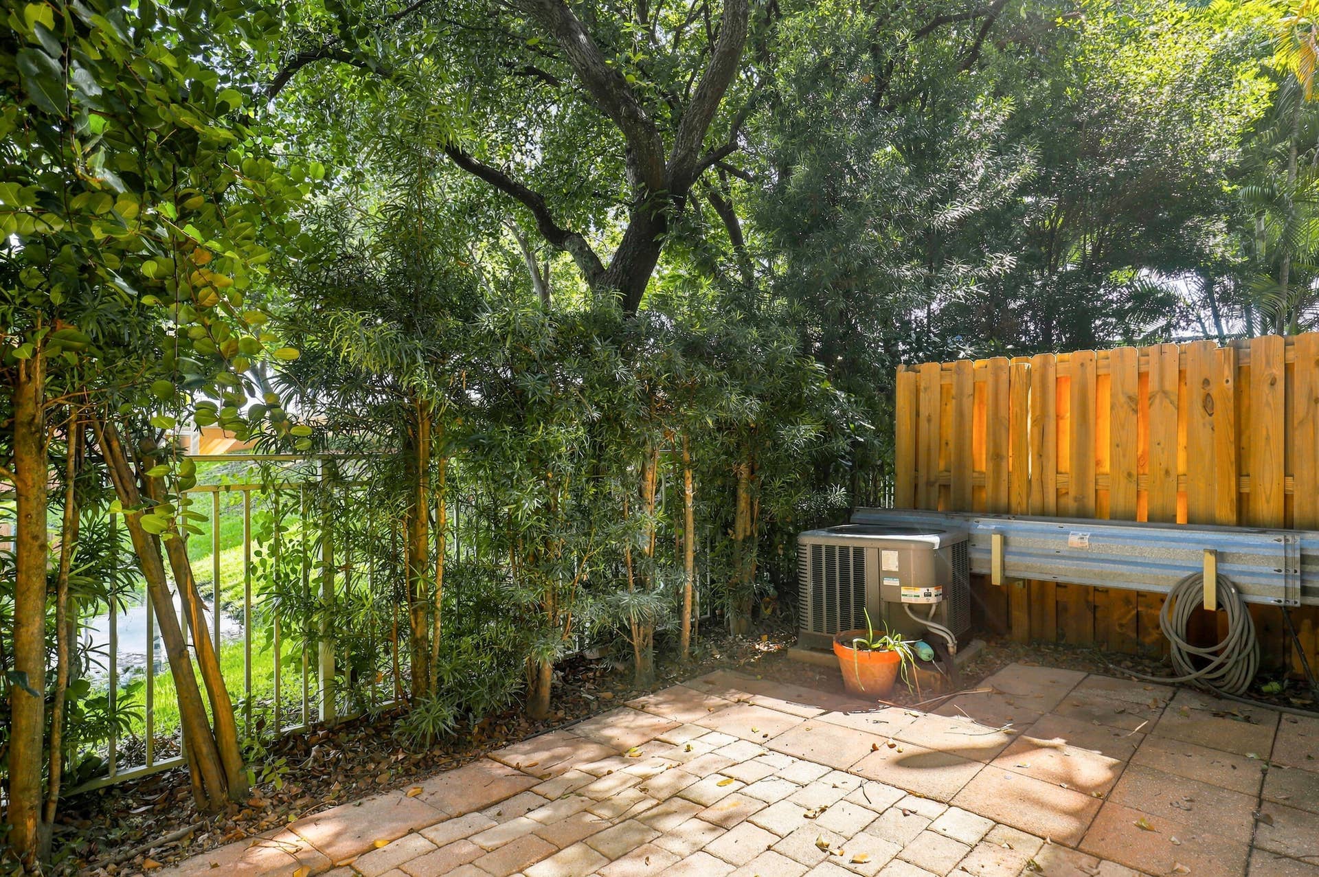 2107 Anchor Court, Fort Lauderdale, FL 33312 Private brick-paver patio surrounded by mature tropical landscaping, offering a peaceful, shaded outdoor space with direct access from the home.